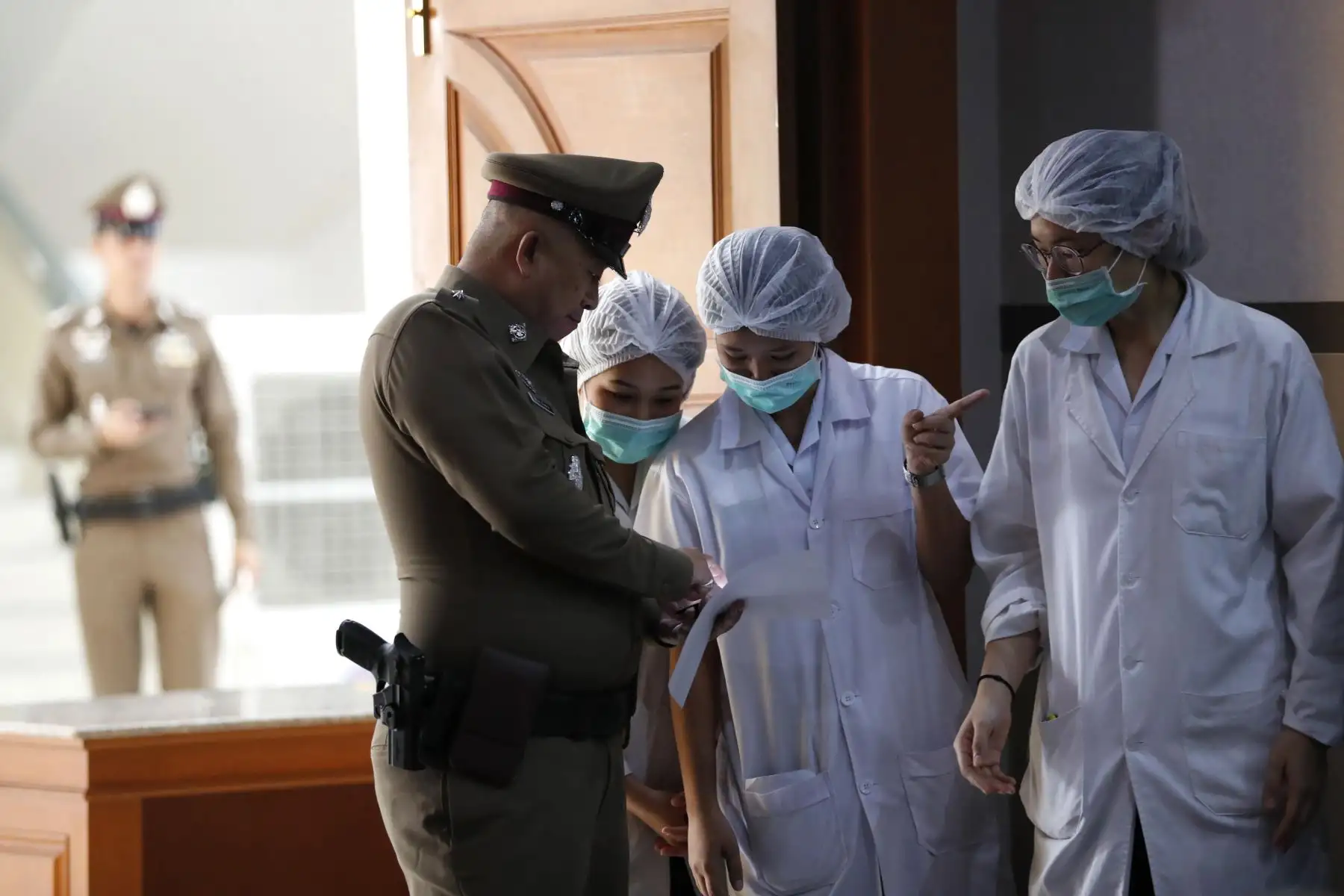 Personal del hospital tailandÈs y un oficial de policÌa son vistos durante una conferencia de prensa sobre la condiciÛn de ocho niÒos despuÈs de que fueron rescatados de la cueva Tham Luang, en el Hospital Chiangrai Prachanukroh en la provincia de Chiang Rai, Tailandia, el 10 de julio de 2018. EFE