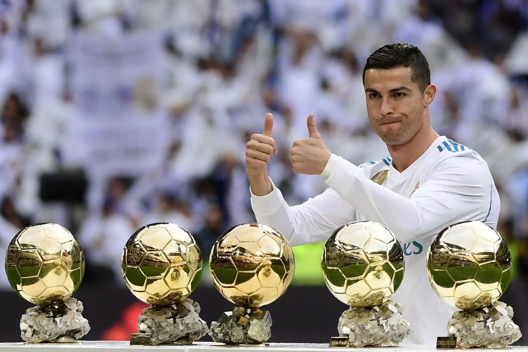 El delantero portugués del Real Madrid Cristiano Ronaldo posa con sus cinco trofeos de Balón de Oro antes del partido de la liga española de fútbol entre Real Madrid y Sevilla en el estadio Santiago Bernabéu de Madrid el 9 de diciembre de 2017. / AFP