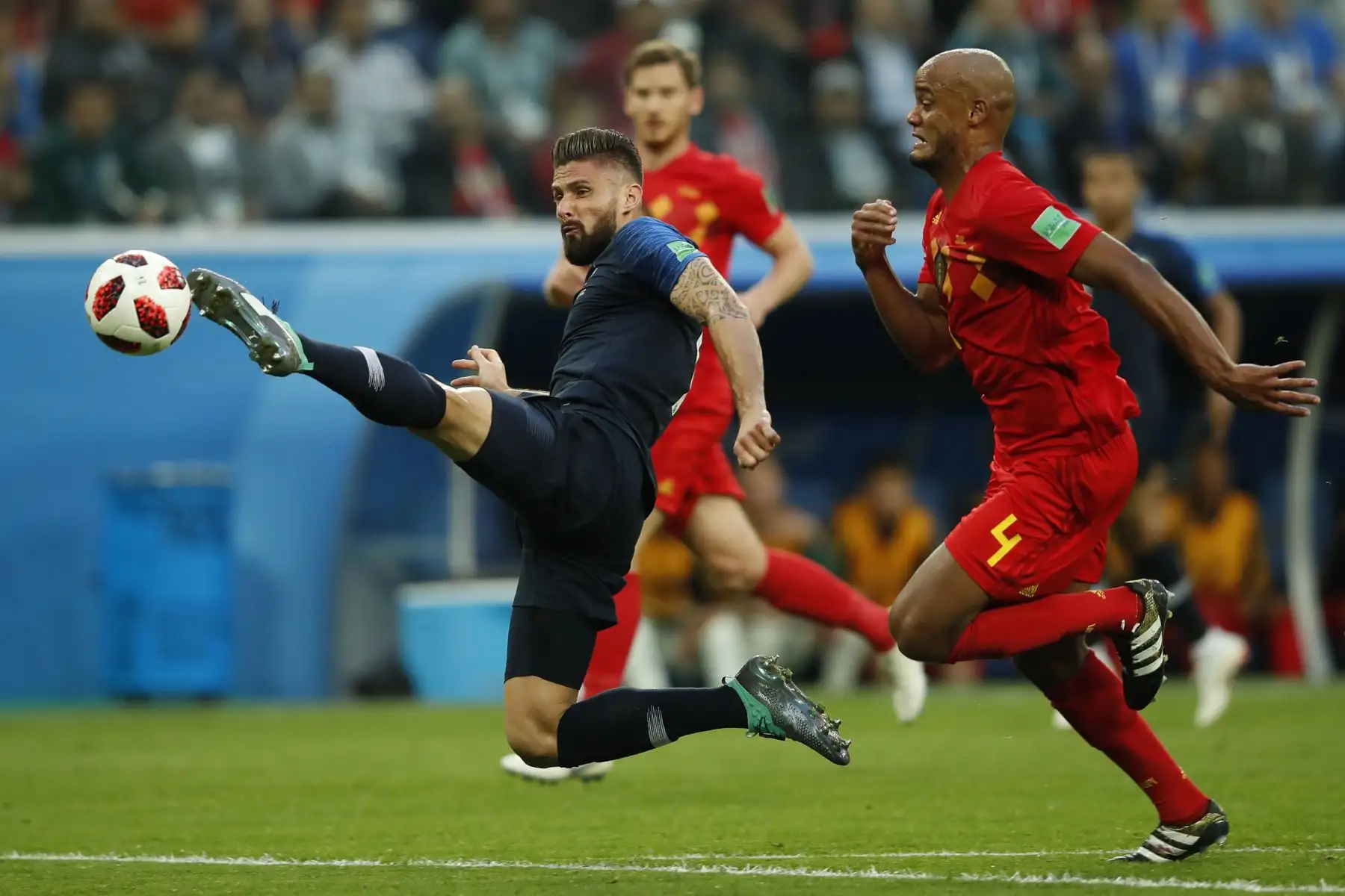 El delantero francés Olivier Giroud (L) controla el balón más allá del defensor Vincent Kompany durante el partido de semifinales de la Copa Mundial Rusia 2018 entre Francia y Bélgica en el estadio de San Petersburgo en San Petersburgo el 10 de julio de 2018. / AFP