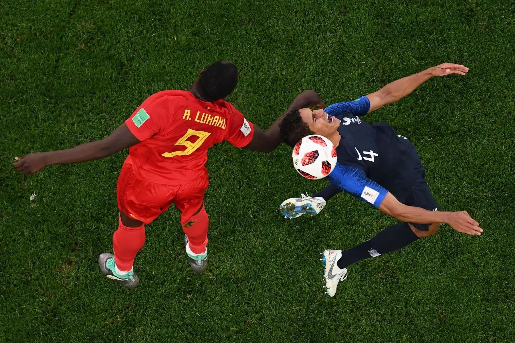 El defensa de Francia Raphael Varane (R) reacciona mientras encabeza el balón junto al delantero belga Romelu Lukaku (L) durante el partido de semifinales de la Copa Mundial Rusia 2018 entre Francia y Bélgica en el estadio de San Petersburgo el 10 de julio de 2018 . / AFP