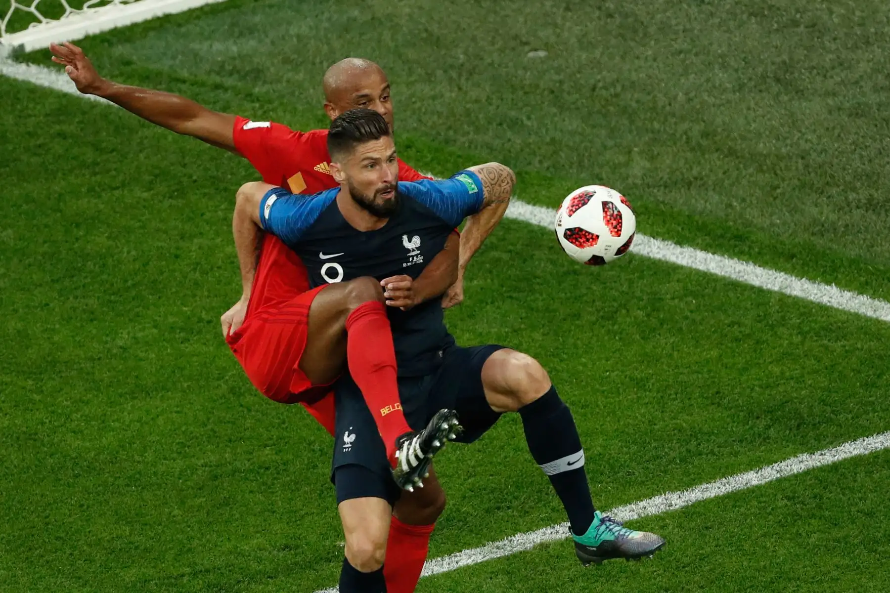 El defensa de Bélgica Vincent Kompany (L) compite por el balón con el alero francés Olivier Giroud durante el partido de semifinales de la Copa Mundial Rusia 2018 entre Francia y Bélgica en el estadio de San Petersburgo el 10 de julio de 2018. / AFP