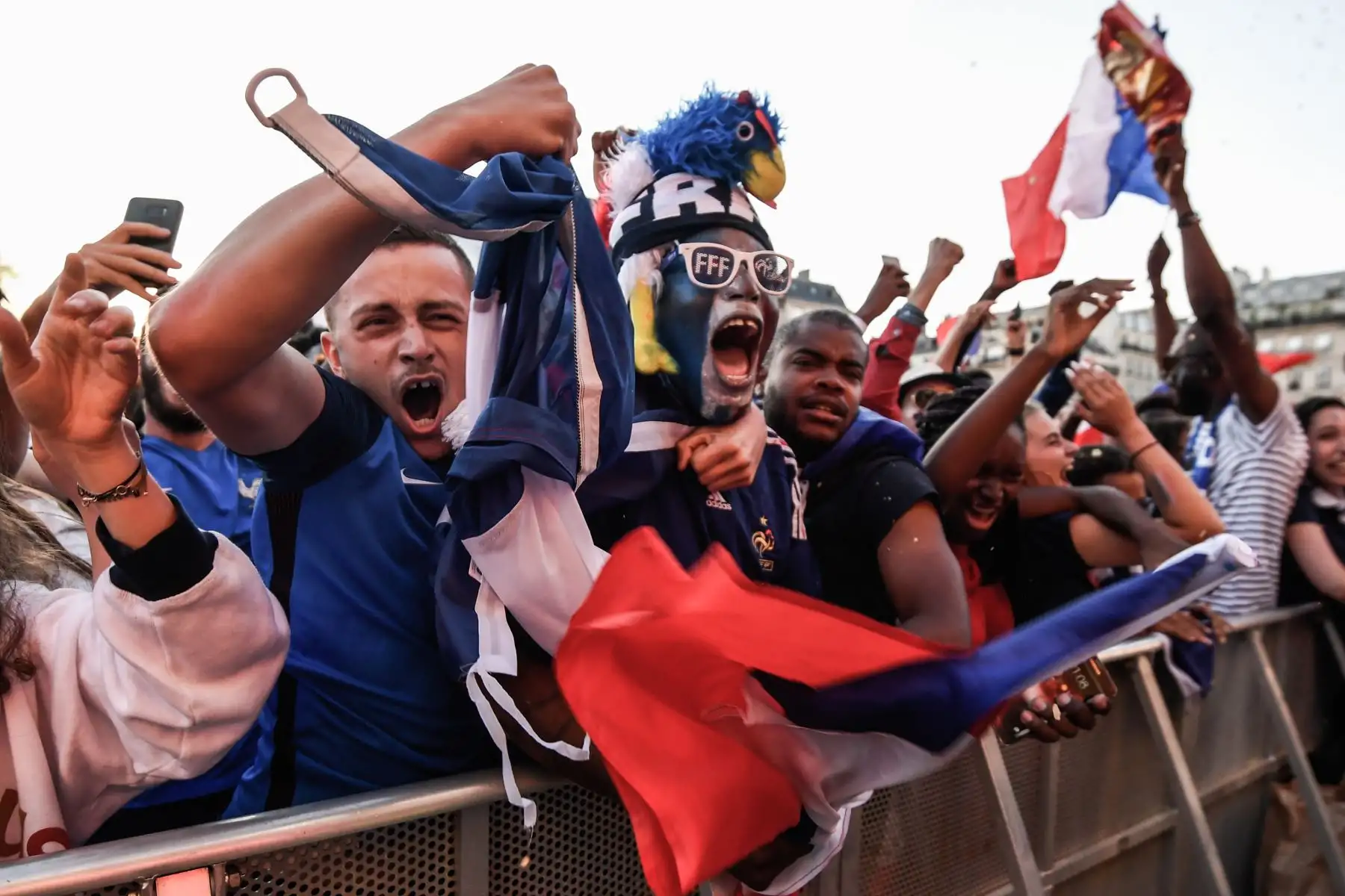 La gente celebra el primer gol de Francia cuando se reúnen en una zona de aficionados en París el 10 de julio de 2018 para ver el partido de fútbol semifinal de la Copa Mundial Rusia 2018 entre Francia y Bélgica. / AFP