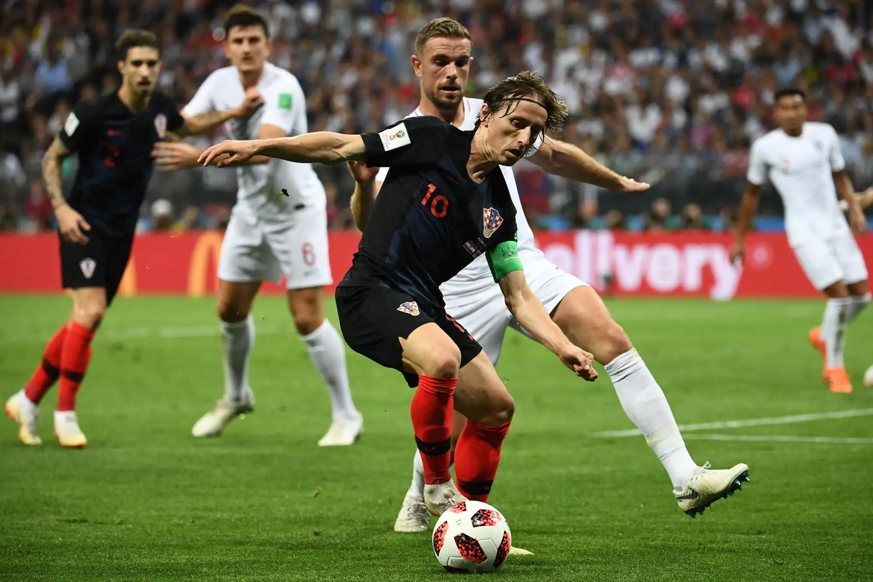 El centrocampista inglés Jordan Henderson (CR) marca al mediocampista croata Luka Modric durante el partido de semifinales de la Copa Mundial Rusia 2018 entre Croacia e Inglaterra en el Estadio Luzhniki de Moscú el 11 de julio de 2018. / AFP