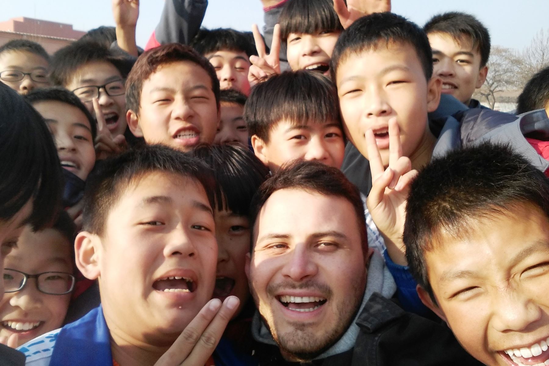 El joven peruano Luis Felipe Checa Calderón junto a un grupo de niños en China. Foto: ANDINA/Sonia Millones.