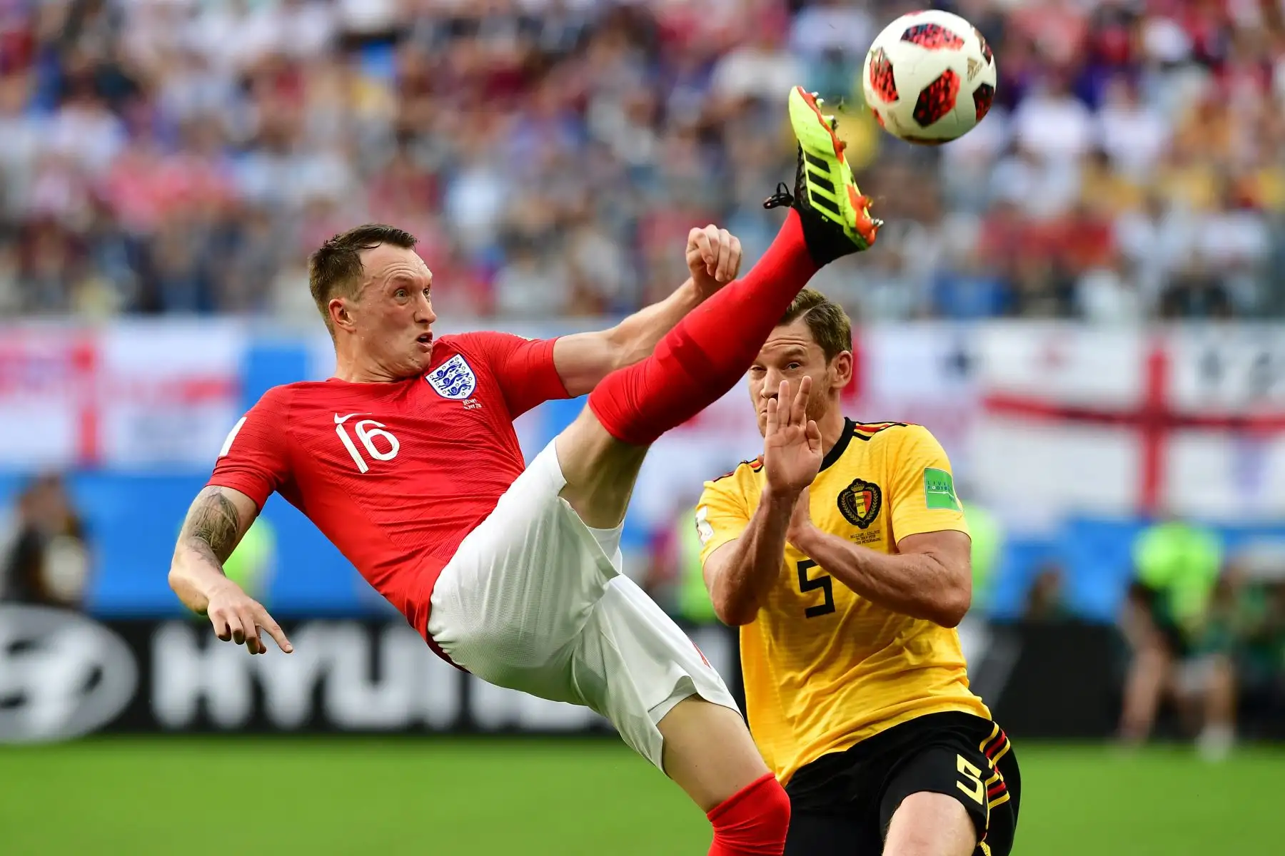 El defensor de Inglaterra Phil Jones (L) hace una patada en bicicleta sobre el defensor belga Jan Vertonghen durante su partido de la Copa Mundial 2018 de Rusia por el partido de fútbol entre Bélgica e Inglaterra en el Estadio de San Petersburgo el 14 de julio de 2018. / AFP