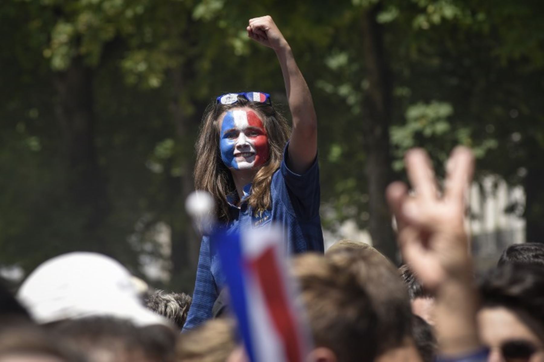 Una partidaria francesa, con su cara pintada con los colores de la bandera francesa, levanta el puño y celebra la final de la Copa Mundial Rusia 2018 . Foto:AFP