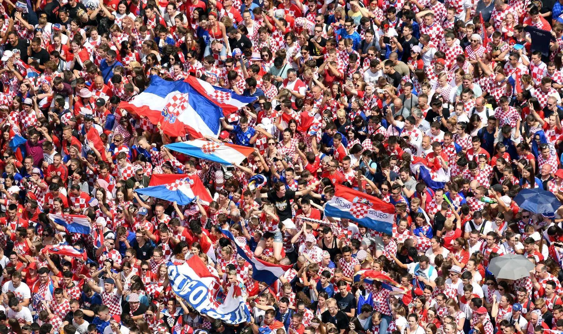 La gente agita banderas mientras se reúnen para una "bienvenida de héroes" en homenaje al equipo nacional de fútbol croata, después de llegar a la final en la Copa Mundial Rusia 2018, en la Plaza Bana Jelacica en Zagreb. AFP