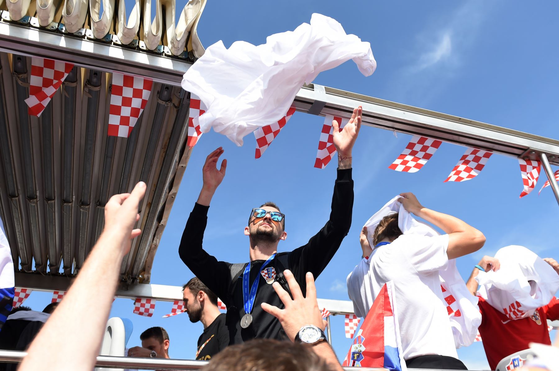 Los jugadores del equipo nacional de fútbol croata entregan sus camisetas a los fanáticos en el Aeropuerto Internacional de Zagreb desde su autocar de techo abierto durante una ceremonia de bienvenida. AFP