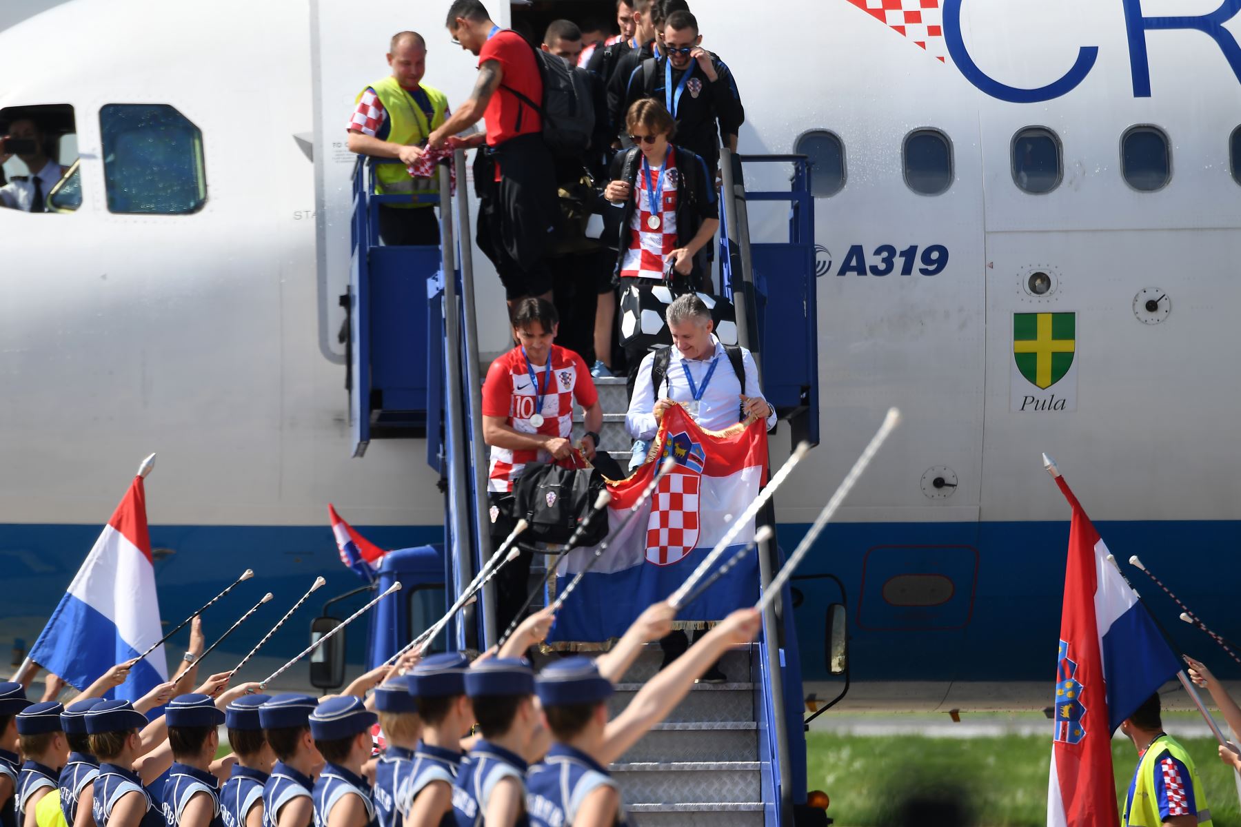 Mejor jugador de la Copa Mundial de la FIFA 2018 en Rusia, Croacia Luka Modric (C) y otros miembros del equipo salen de su avión Airbus a319 en el aeropuerto internacional de Zagreb. AFP