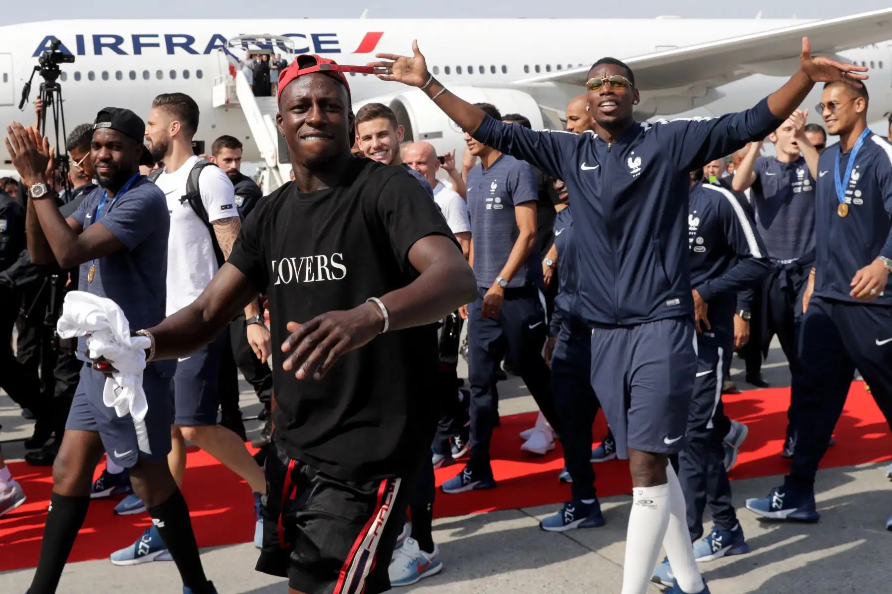 El defensa francés Samuel Umtiti, el defensor francés Benjamin Mendy y el centrocampista francés Paul Pogba celebran después de desembarcar del avión a su llegada al aeropuerto Roissy-Charles de Gaulle en las afueras de París, después de ganar la final de la Copa Mundial Rusia 2018 partido de fútbol. AFP