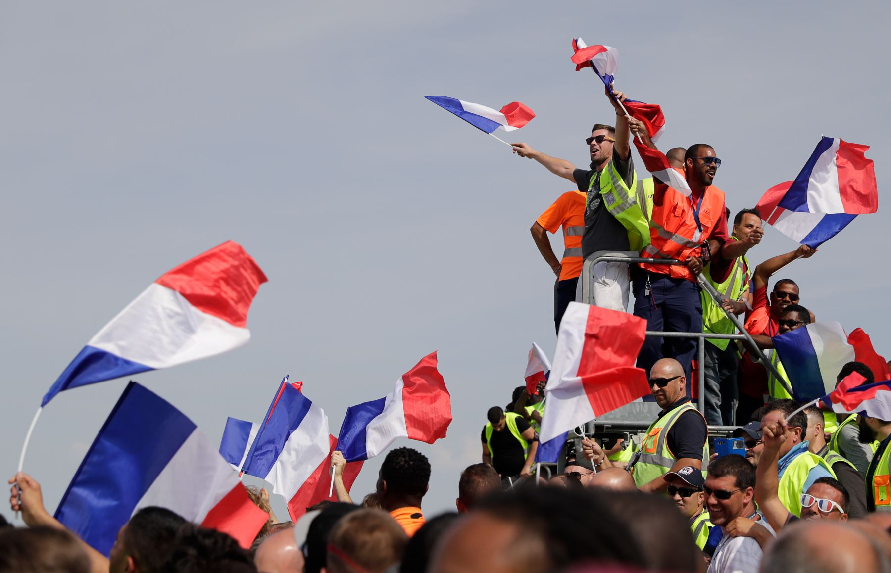 Los fanáticos de Francia agitan banderas nacionales francesas mientras esperan la llegada del equipo nacional de fútbol de Francia al Roissy-Charles de Gaulle. AFP