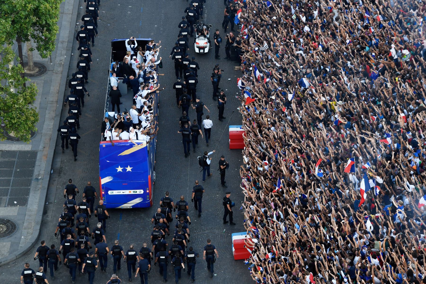 Los fanáticos de Francia saludan a los jugadores del equipo nacional de fútbol de Francia mientras celebran en el techo de un autobús mientras desfilan por la avenida Champs-Elysee en París. AFP