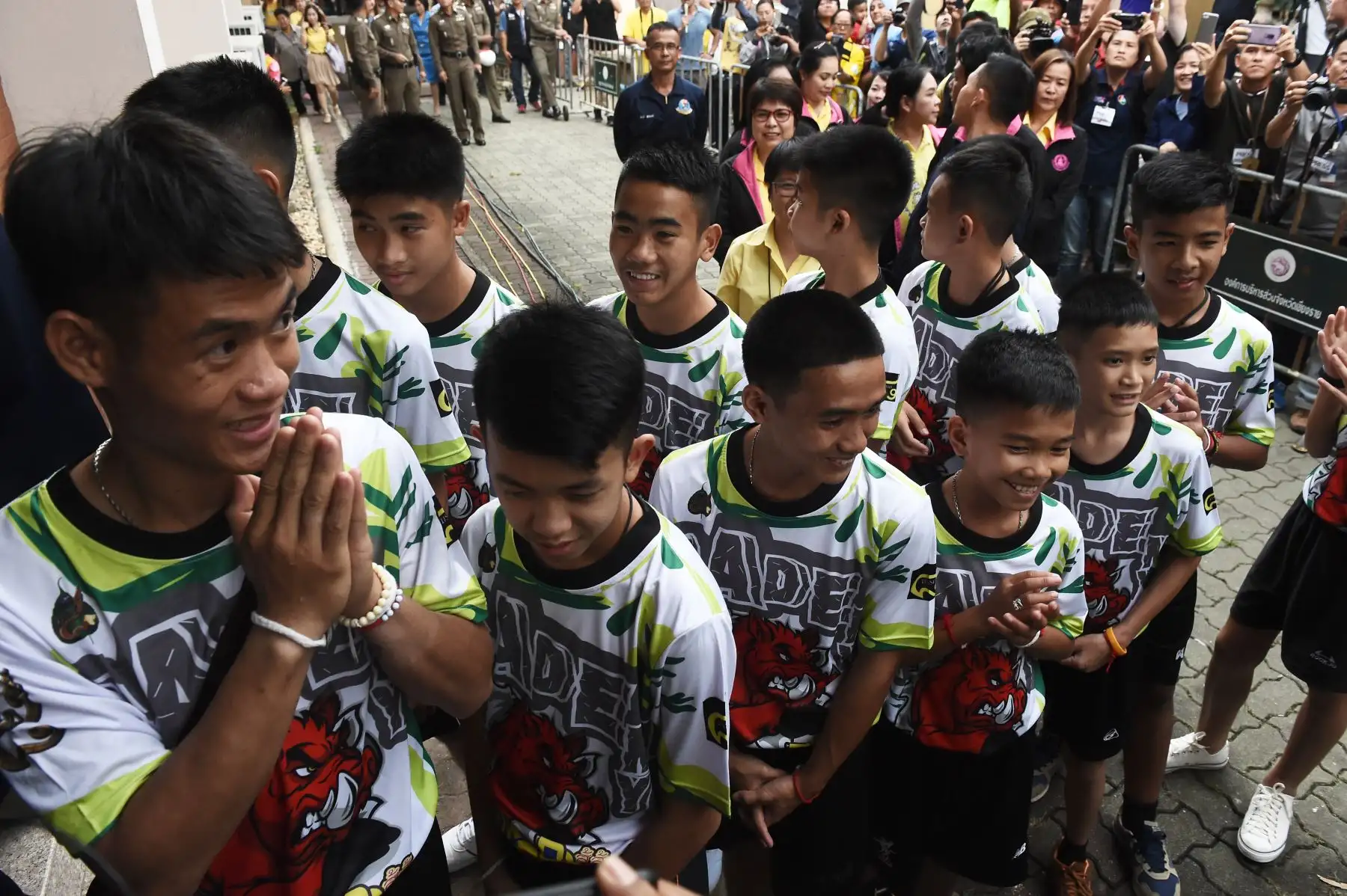 Doce niños y su entrenador de fútbol Ekkapol Chantawong (C), dramáticamente rescatados del interior de una cueva tailandesa después de estar atrapados por más de una quincena, llegan a una conferencia de prensa en Chiang Rai el 18 de julio de 2018, tras su alta del hospital.
Los jóvenes futbolistas y su entrenador parecían sanos cuando comparecieron ante los medios por primera vez el 18 de julio. / AFP