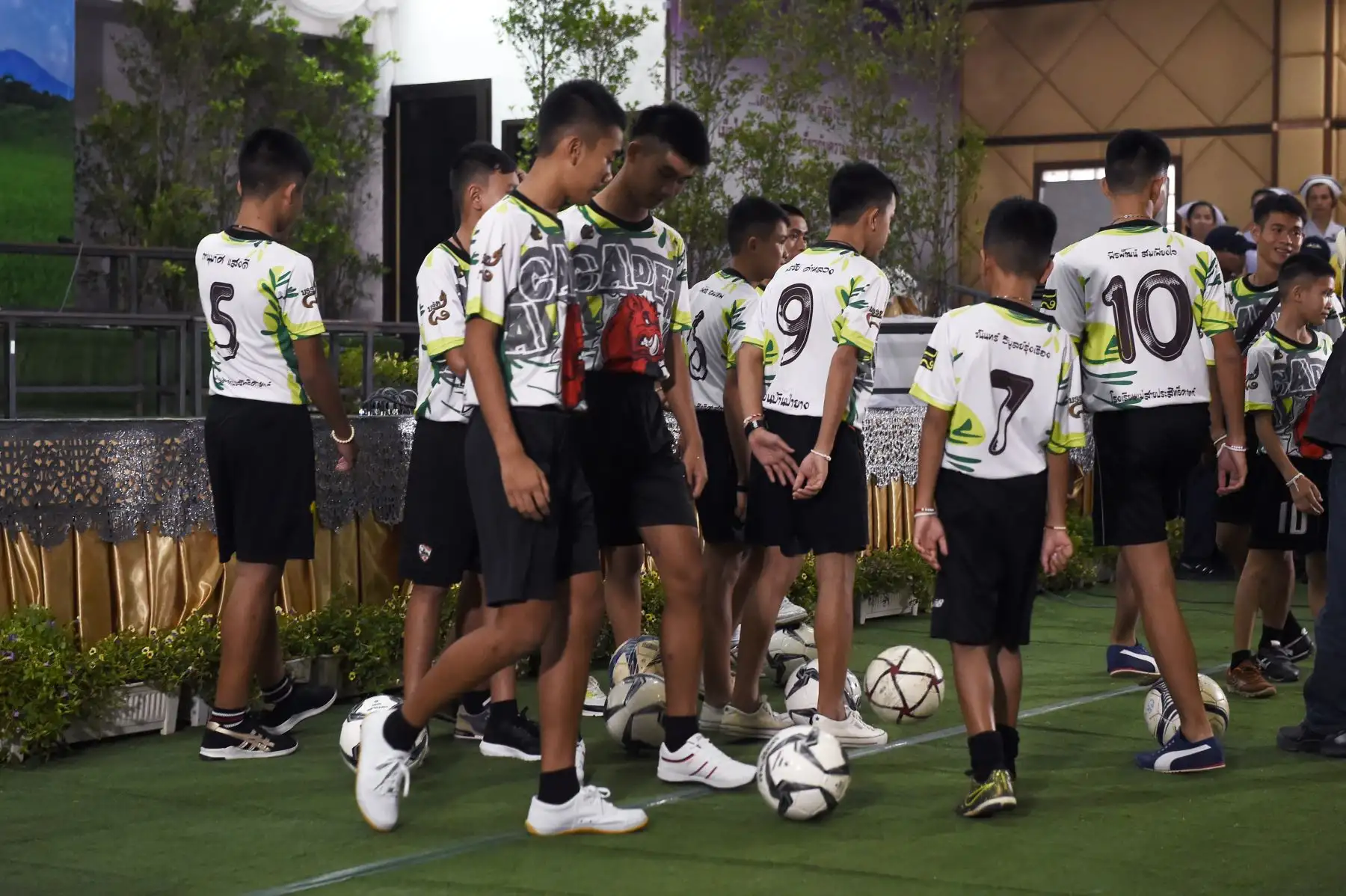 Algunos de los muchachos, rescatados dramáticamente de las profundidades de una cueva, después de estar atrapados por más de una quincena, jugar con balones de fútbol antes de una conferencia de prensa en Chiang Rai el 18 de julio de 2018, tras su alta del hospital .
Los jugadores jóvenes y su entrenador de fútbol parecían sanos cuando se comparaban con los medios por primera vez el 18 de julio. / AFP