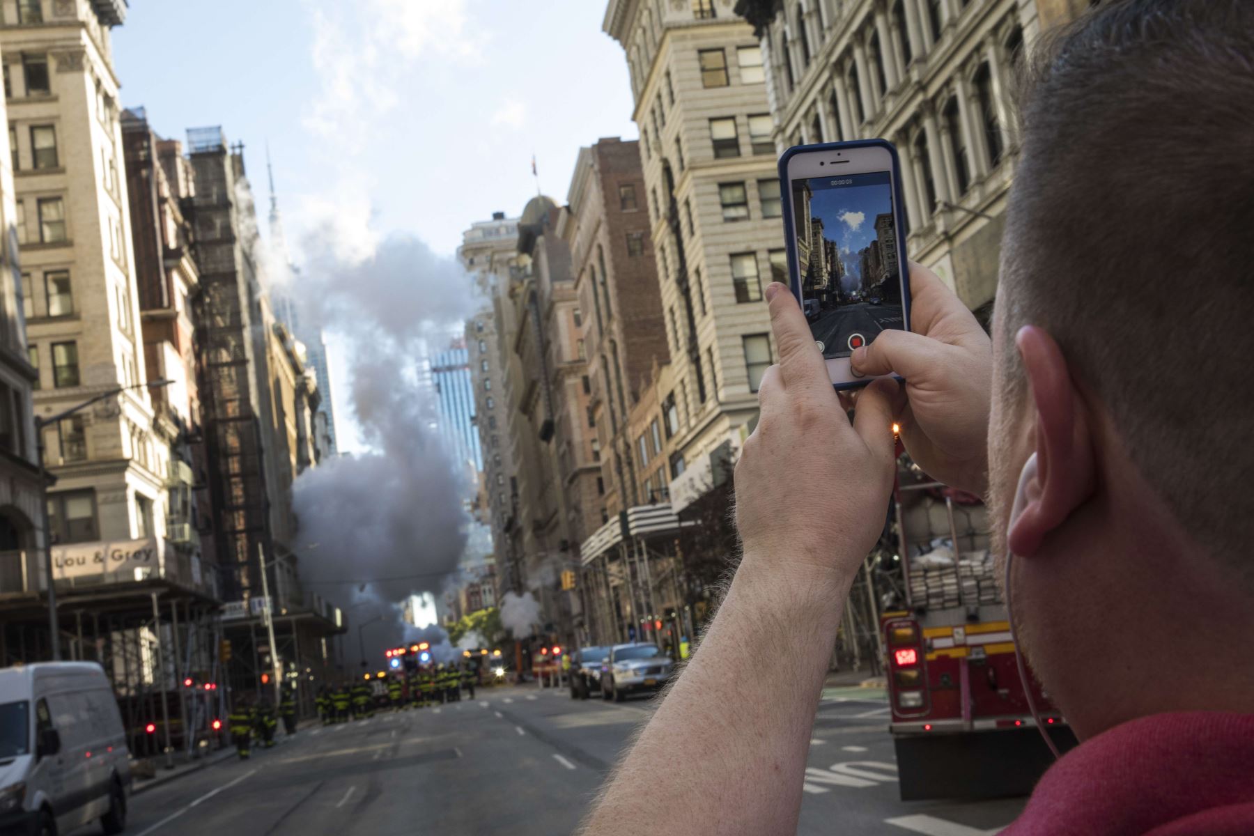 Un hombre toma una foto de una explosión de la tubería de vapor en la Quinta Avenida Nueva York Foto: AFP