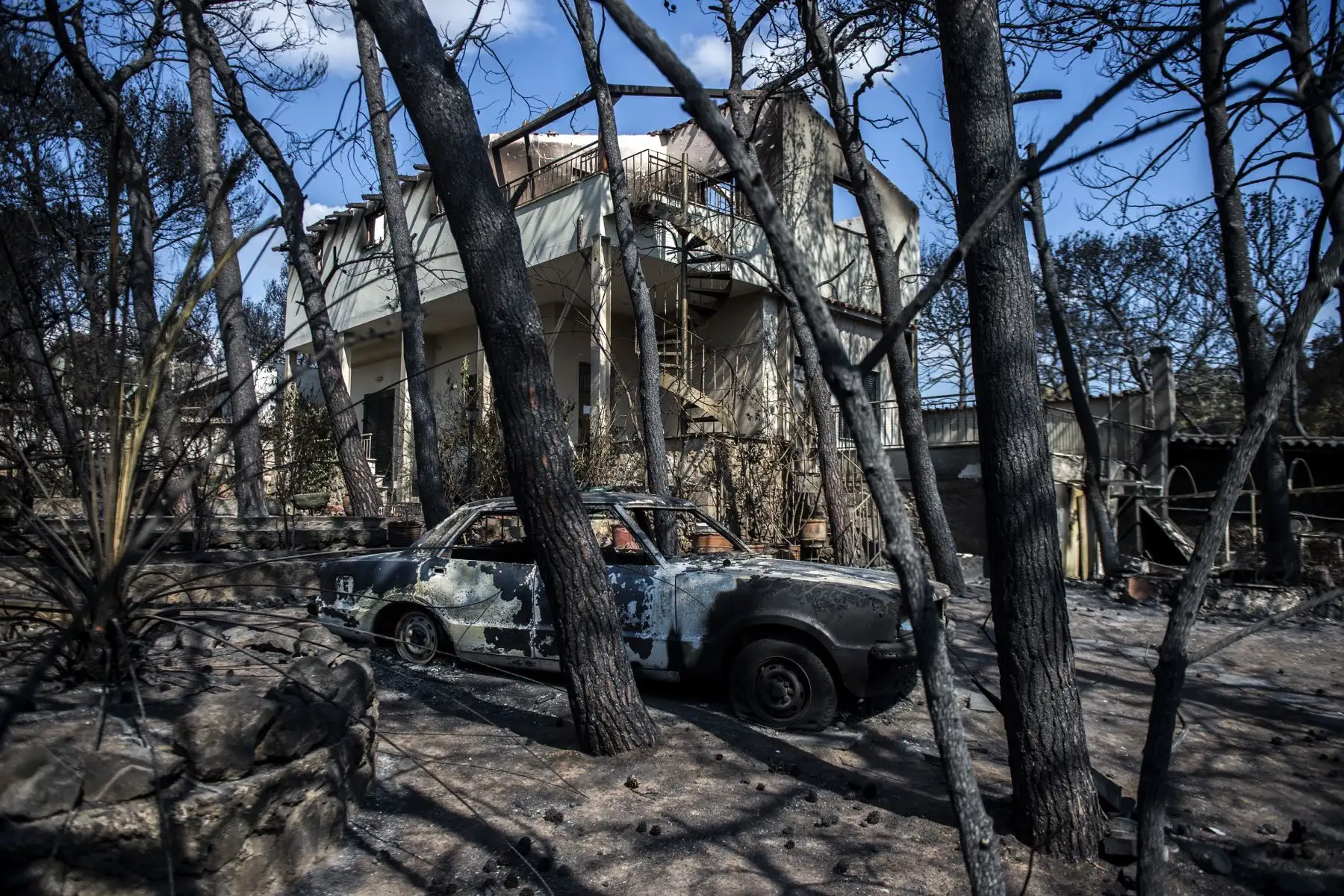 Una foto tomada el 25 de julio de 2018 muestra autos quemados después de un incendio forestal en el pueblo de Mati, cerca de Atenas. AFP
