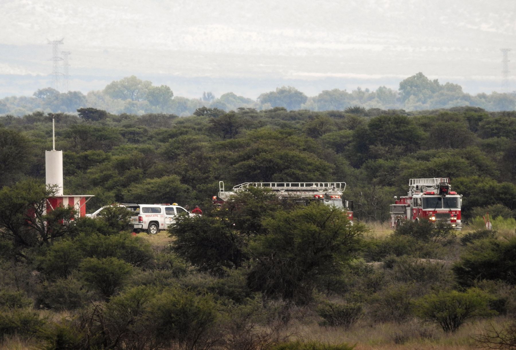 Los camiones de bomberos se ven cerca de los restos de un avión (fuera de cuadro) que se estrelló con 97 pasajeros y cuatro tripulantes a bordo en el despegue en el aeropuerto de Durango, en el norte de México, el 31 de julio de 2018.Foto: AFP