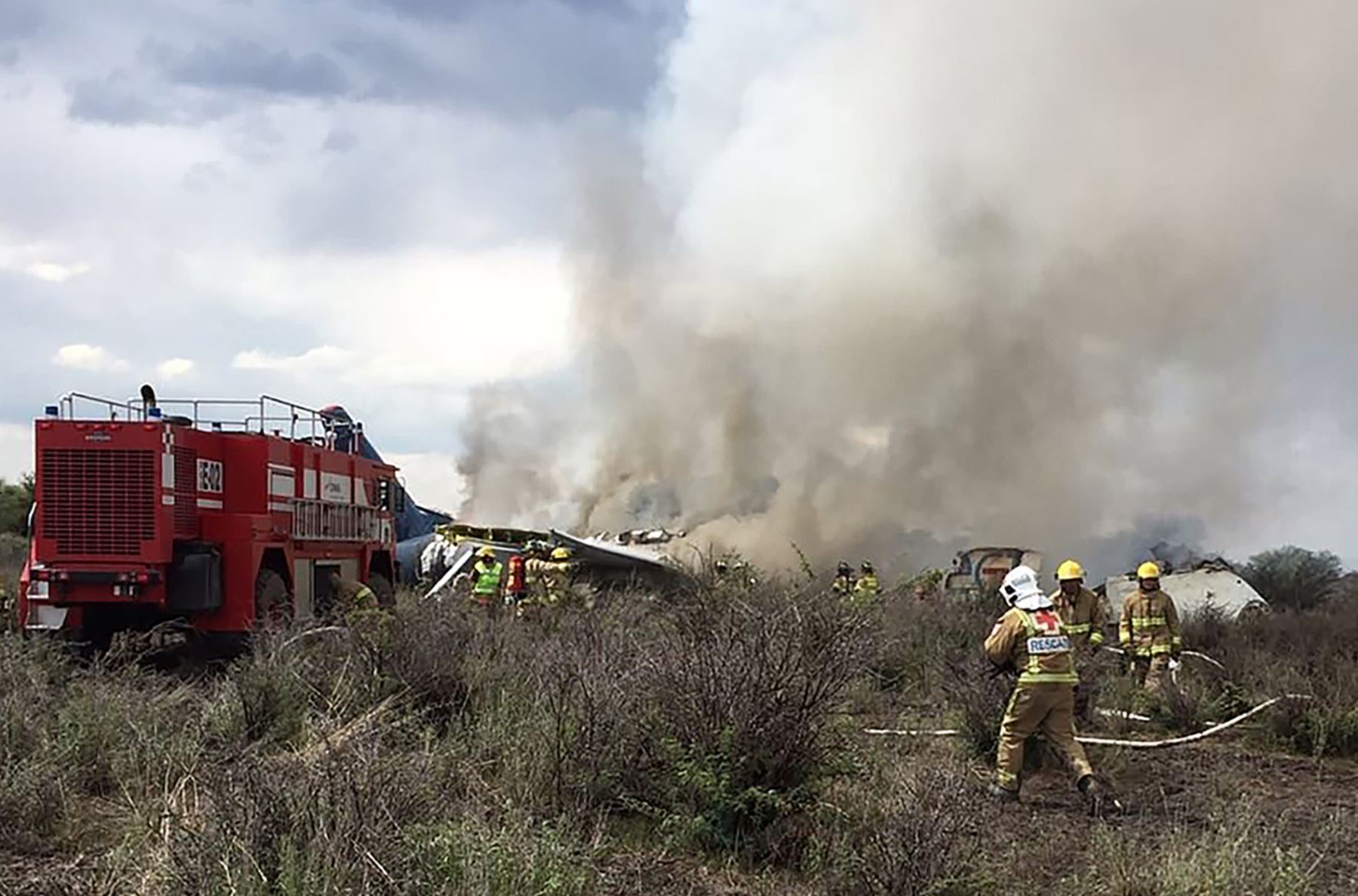 Los bomberos trabajan en rescate en los restos de un avión que se estrelló con 97 pasajeros y cuatro tripulantes a bordo en despegue en el aeropuerto de Durango, en el norte de México, el 31 de julio de 2018. AFP