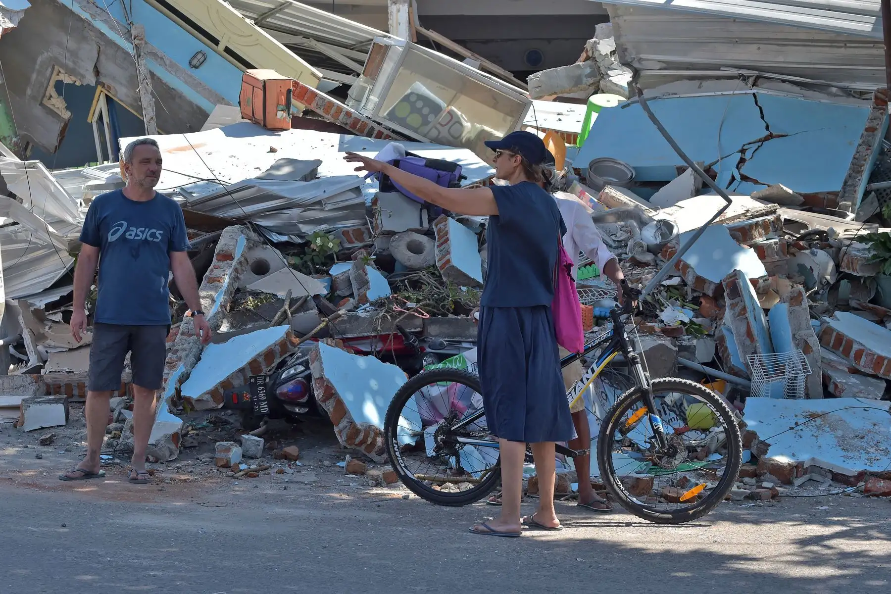 Los turistas extranjeros (R y L) preguntan a un hombre local (detrás) cuando pasan frente a casas dañadas en el puerto de Bangsal en la isla indonesia de Lombok el 6 de agosto de 2018, un día después de que un terremoto de 6.9 grados golpeara la zona.
Más de 1.000 turistas fueron evacuados de las pequeñas islas Gili de Indonesia el 6 de agosto, luego de que un poderoso terremoto azotara a la vecina Lombok, matando a 91 personas y dejando cientos de heridos. / AFP