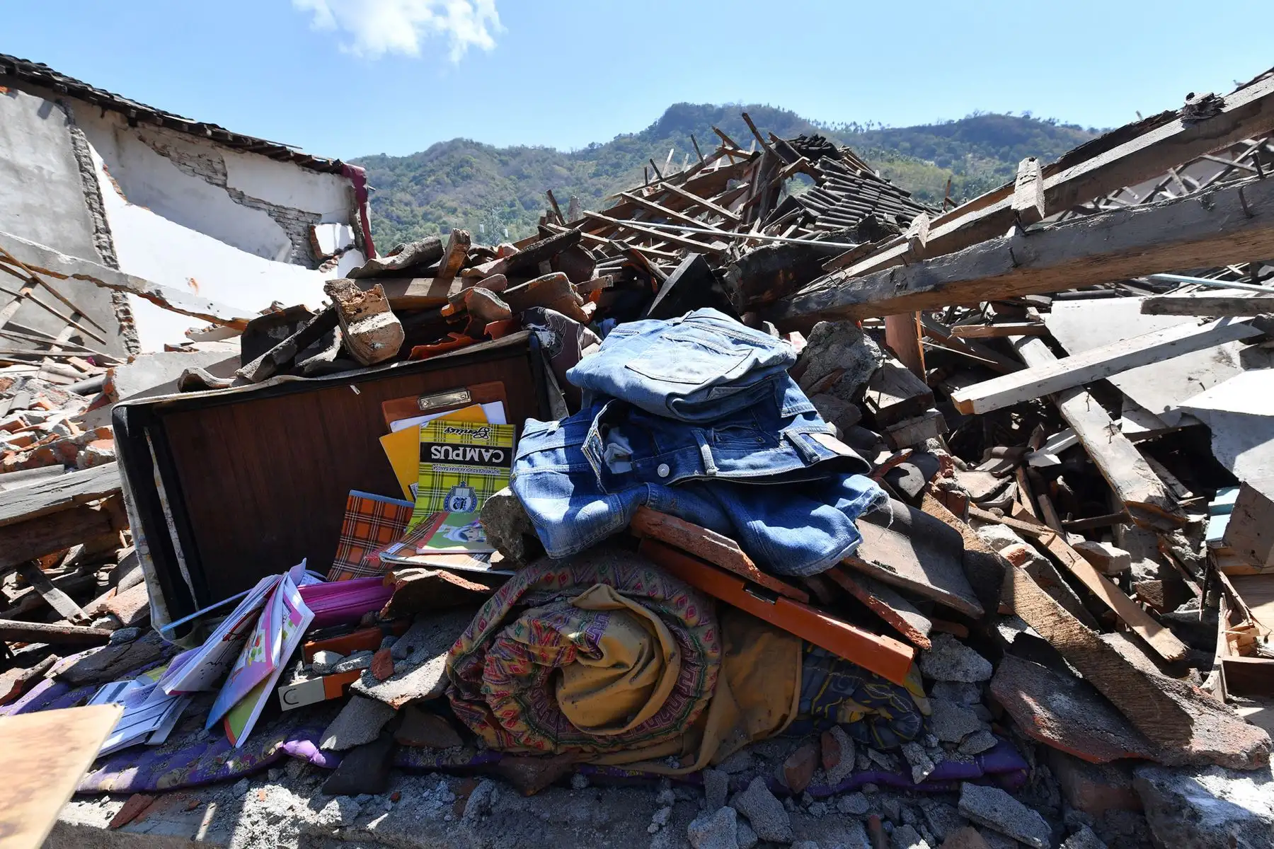 Los artículos recuperados se sientan junto a los edificios destruidos en Pemenang, en el norte de Lombok, el 6 de agosto de 2018, un día después de que un terremoto de 6.9 grados de magnitud sacudiera la zona. AFP
