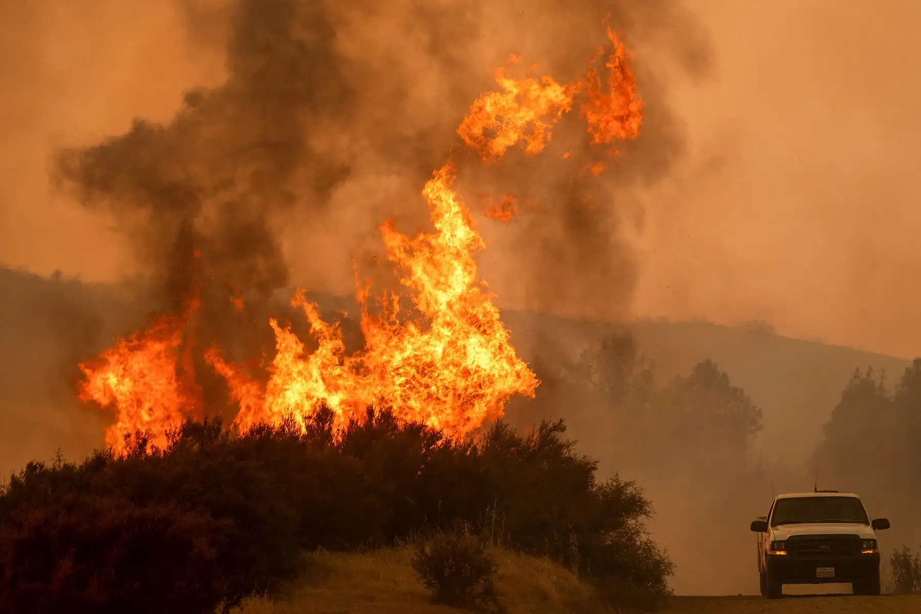 Las llamas saltan sobre un vehículo en High Valley Rd mientras el incendio de Ranch, parte del incendio complejo Mendocino, arde cerca de Clearlake Oaks, California. AFP