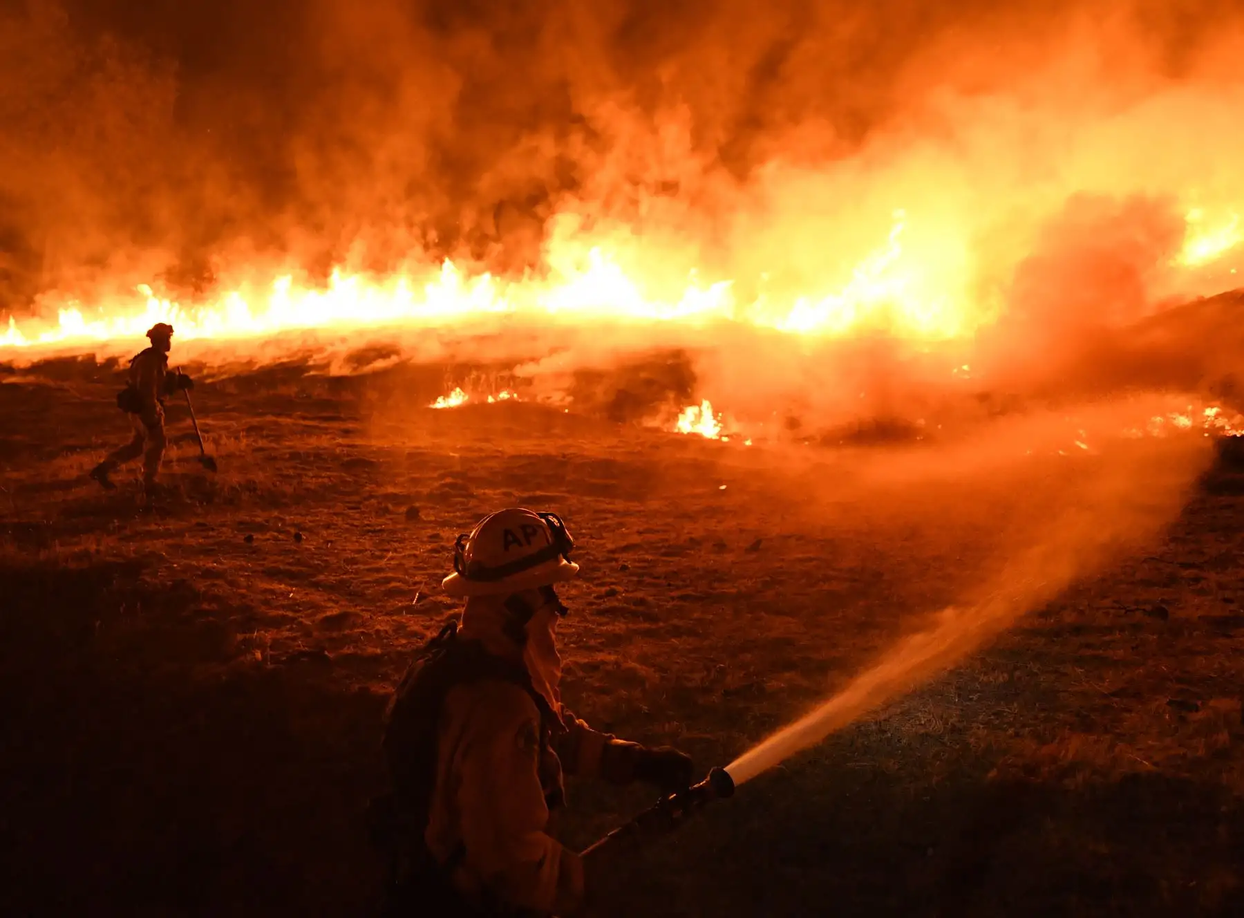 Los bomberos llevan a cabo una quema controlada para defender las casas de las llamas del incendio de Rancho, parte del incendio complejo de Mendocino, mientras continúa propagándose hacia la ciudad de Upper Lake, California. AFP