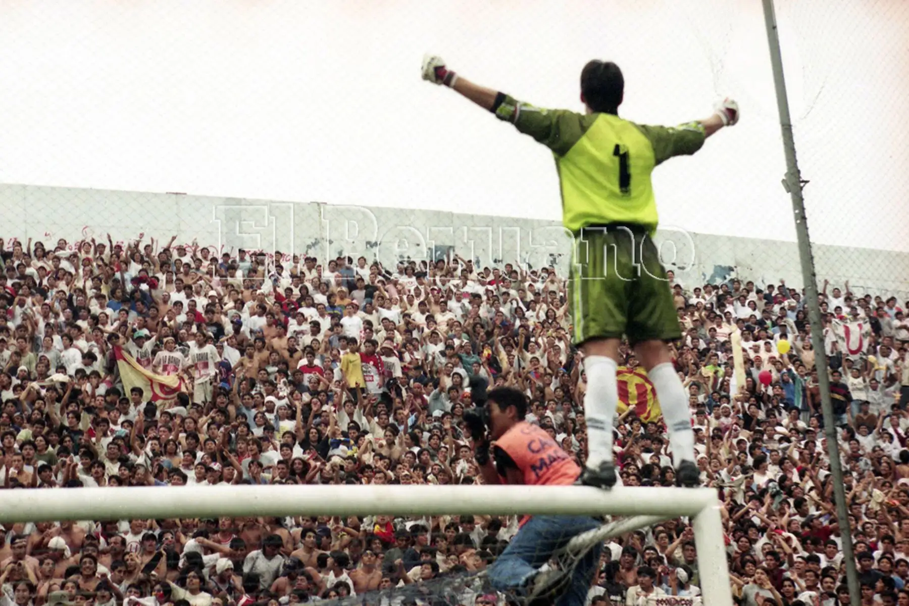 El portero Óscar Ibáñez celebra con su hinchada trepado en  el arco. Universitario de de Deportes se coronó campeón del Torneo Descentralizado en el estadio de Matute pese a perder 0-1 ante Alianza Lima. En el primer partido del play off los cremas habían vencido 3-0.  (20 diciembre 1999).  Foto: Diario Oficial EL PERUANO.