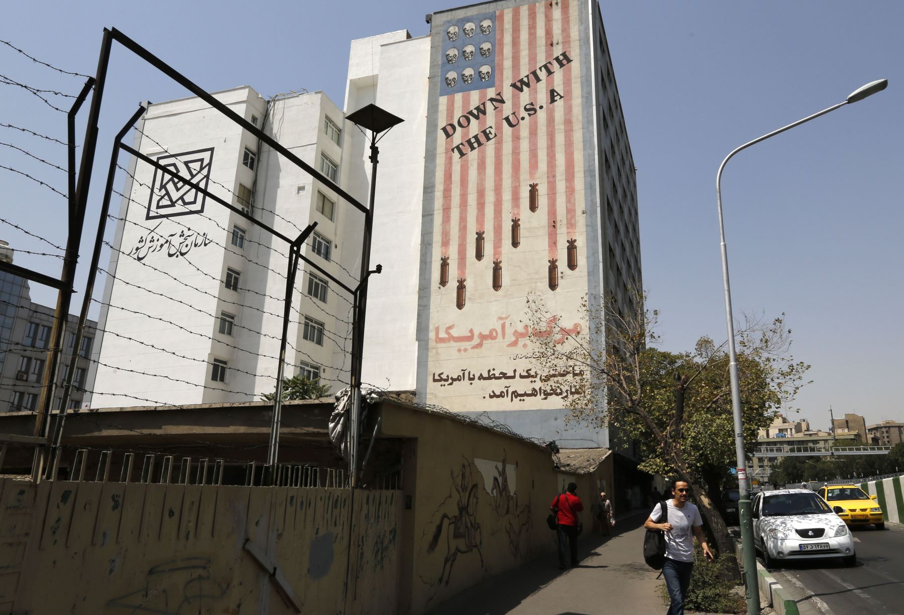 Mural que muestra una bandera estadounidense que tiene cráneos en lugar de las estrellas en el centro de Teherán Foto: AFP