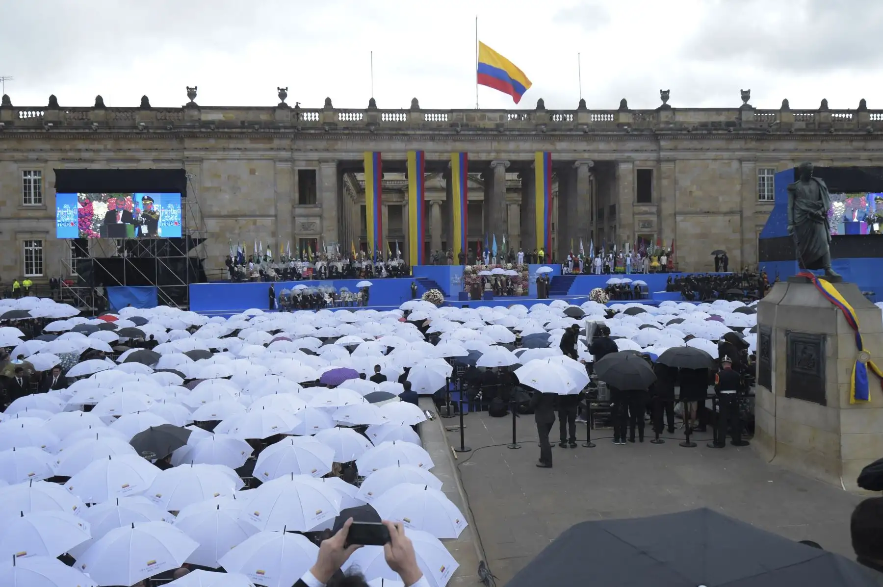 Los invitados se cubren con paraguas durante la inauguración del nuevo presidente colombiano Ivan Duque en la Plaza Bolívar de Bogotá, el 7 de agosto de 2018. AFP