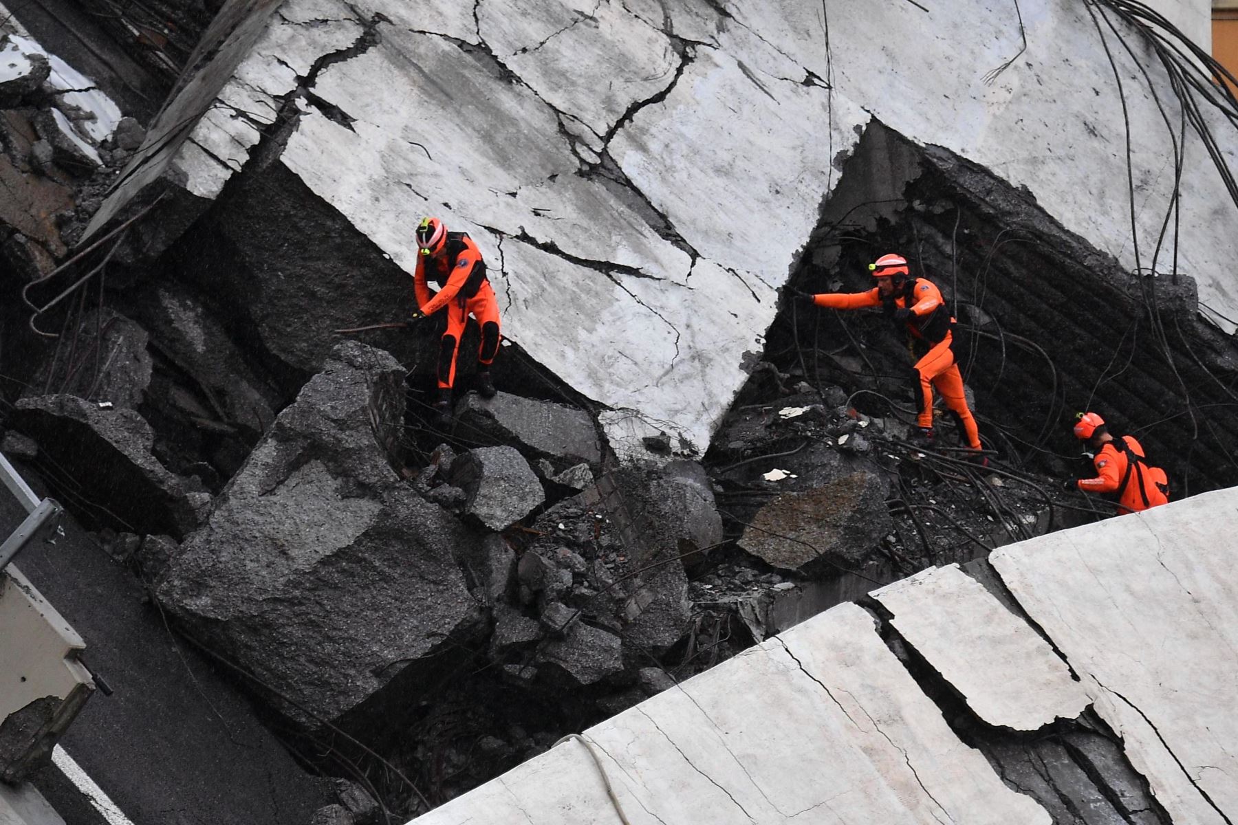 Miembros de los servicios de emergencia trabajan entre los escombros tras derrumbarse una sección del viaducto Morandi en Génova (Italia) hoy, 14 de agosto de 2018. EFE