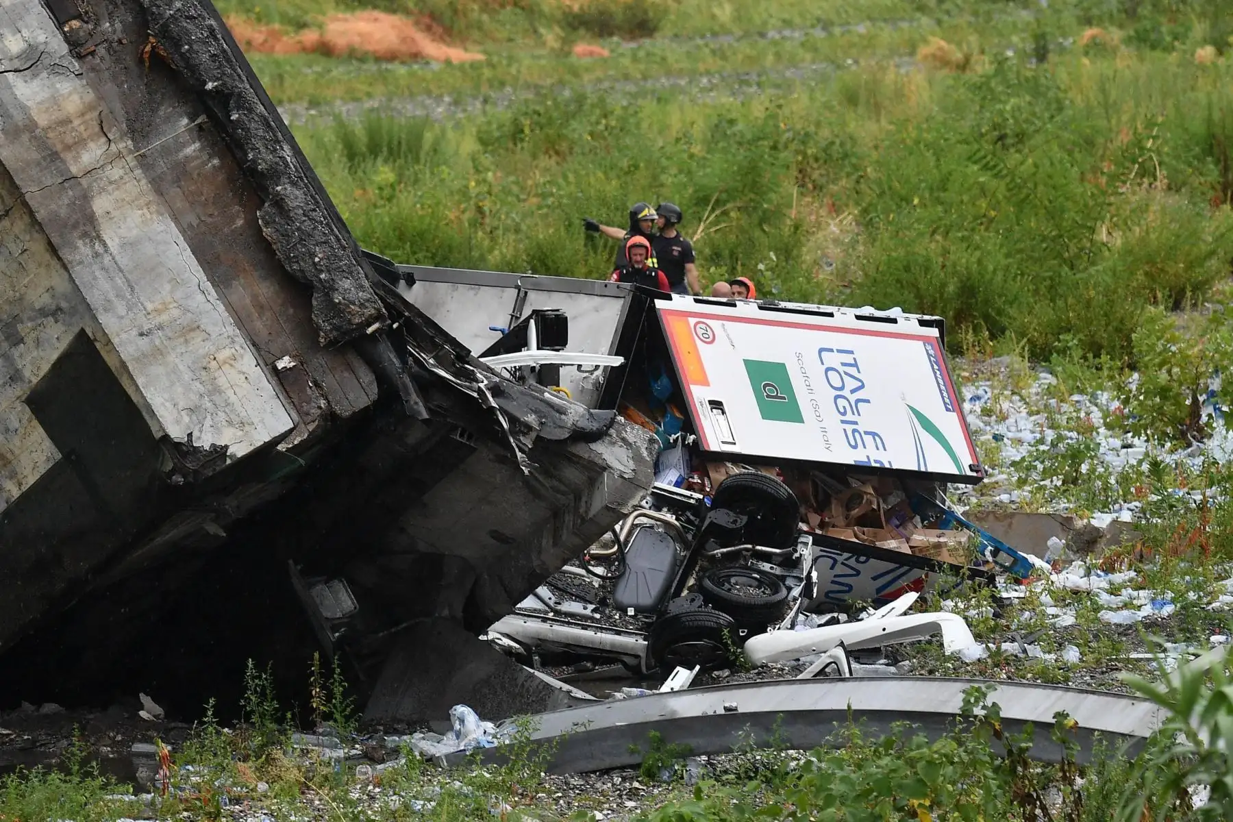 Miembros de los servicios de emergencia trabajan entre los escombros tras derrumbarse una sección del viaducto Morandi en Génova (Italia) hoy, 14 de agosto de 2018. EFE