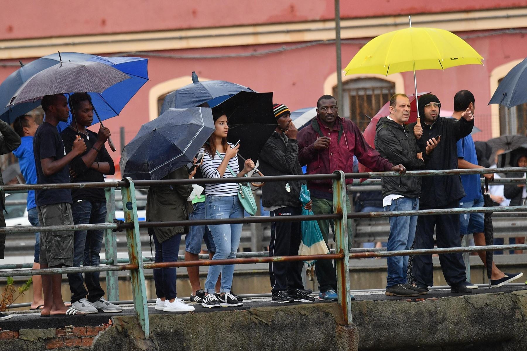 Varios ciudadanos observan los trabajos de los miembros de los servicios de emergencia tras derrumbarse una sección del viaducto Morandi en Génova (Italia) hoy, 14 de agosto de 2018. EFE