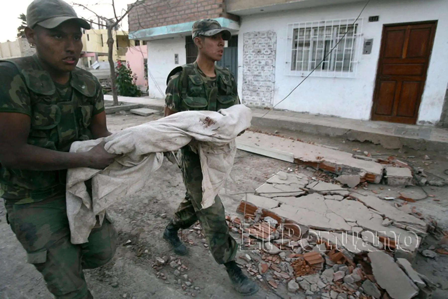 Dos miembros del Ejército trasladan el cuerpo de un infante fallecido en la ciudad de Pisco (16 de agosto del 2007). Foto: Diario Oficial EL PERUANO / Carlos Lezama
