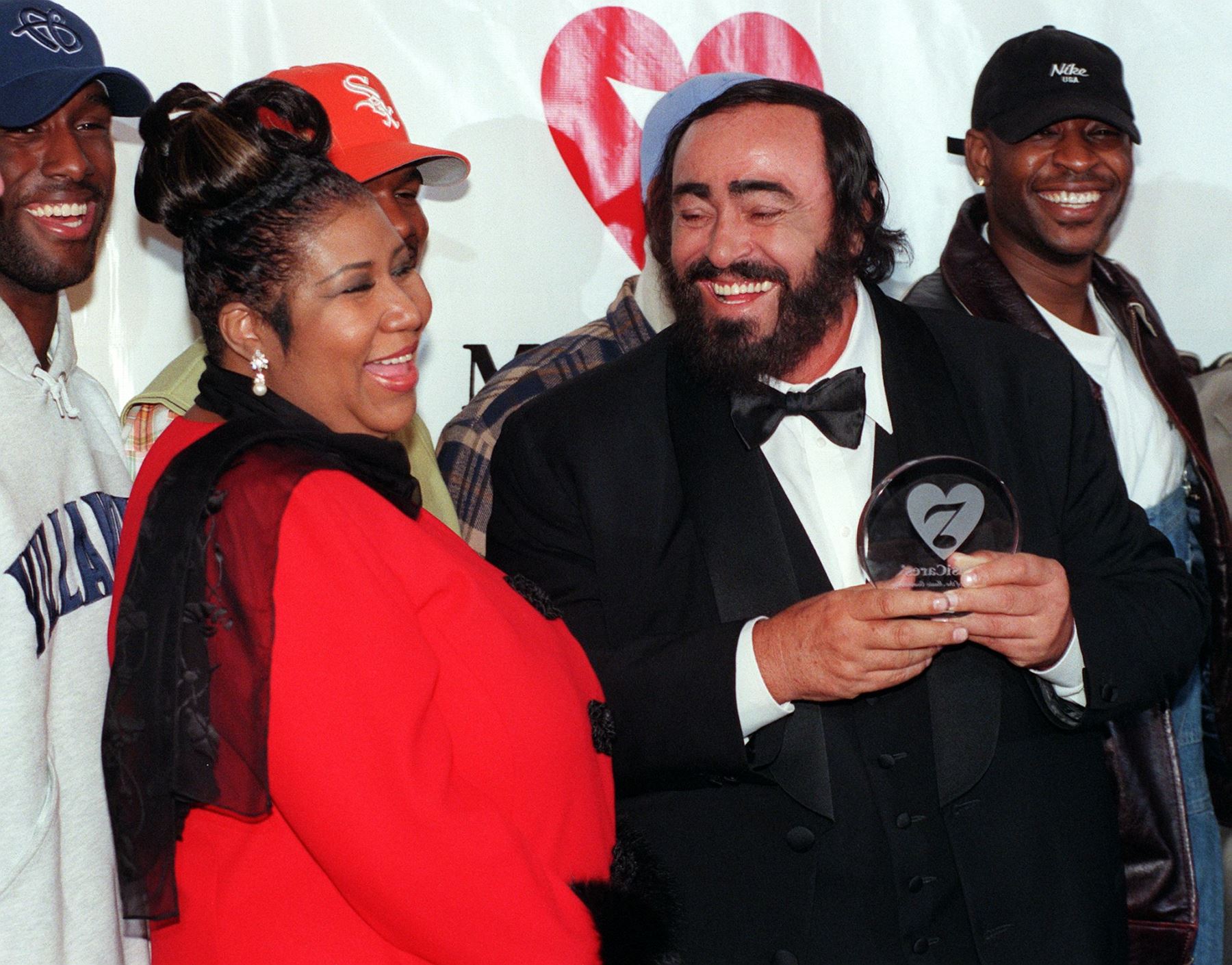 En esta foto de archivo tomada el 23 de febrero de 1998, el cantante de ópera Luciano Pavarotti (R) se ríe junto con la cantante Aretha Franklin (L) y el grupo Boyz II Men (trasero) después de aceptar la octava Fundación MusiCares "Persona del año" premio en Nueva York.