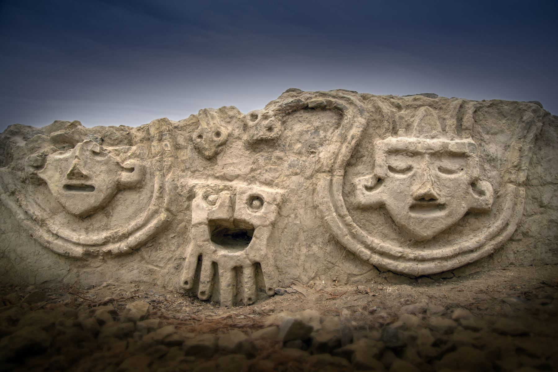 El muro, que tendría una antigüedad de alrededor de 3,800 años, consiste en cuatro cabezas humanas con los ojos cerrados, una al lado de la otra, y dos serpientes. Foto: ANDINA/Zona Arqueológica de Caral
