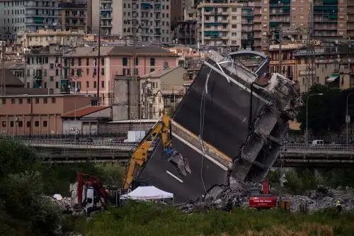 Rescatistas trabajan entre los escombros y restos del puente de la autopista Morandi Foto: AFP