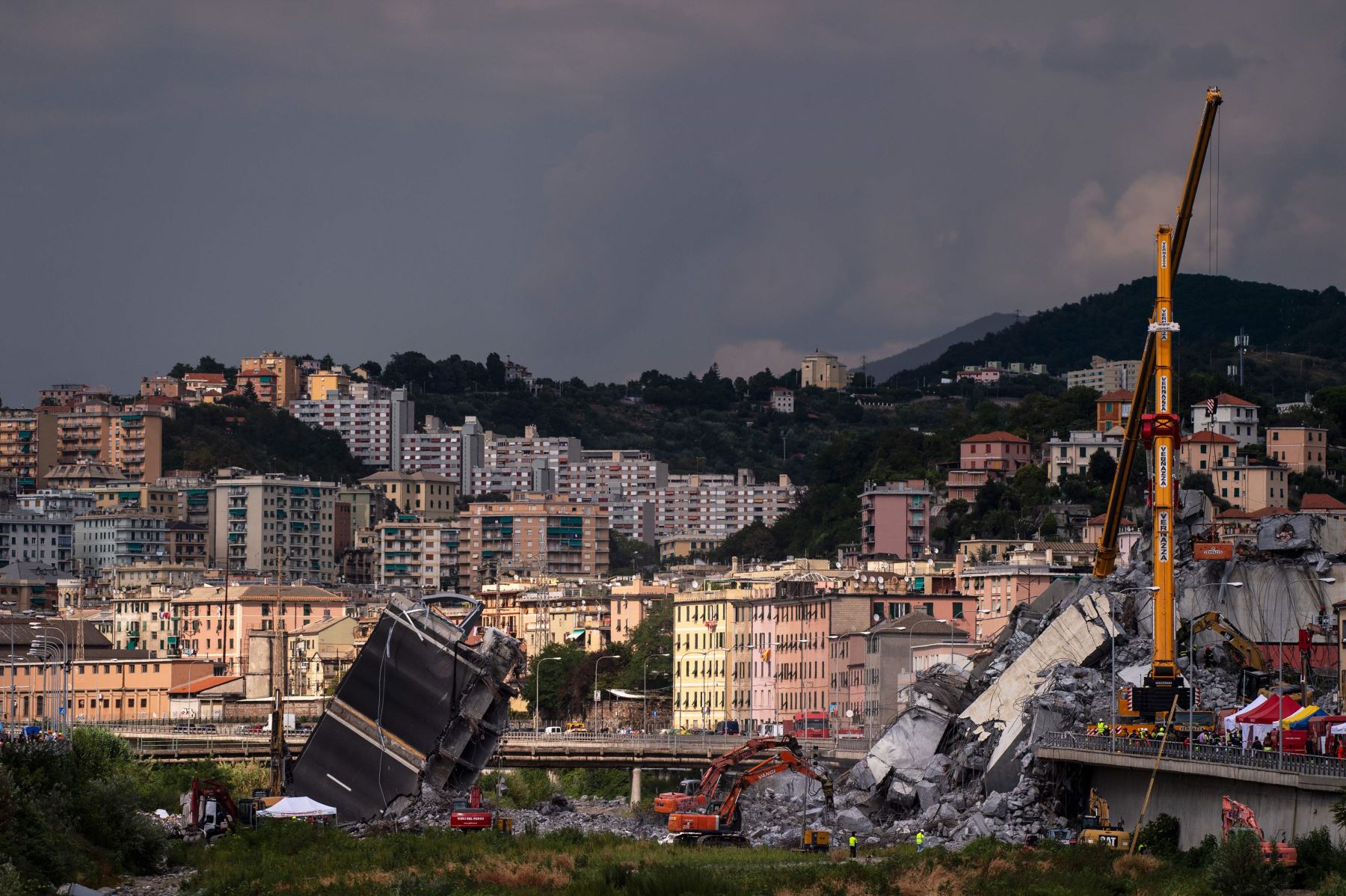 Rescatistas trabajan entre los escombros y restos del puente de la autopista Morandi Foto: AFP
