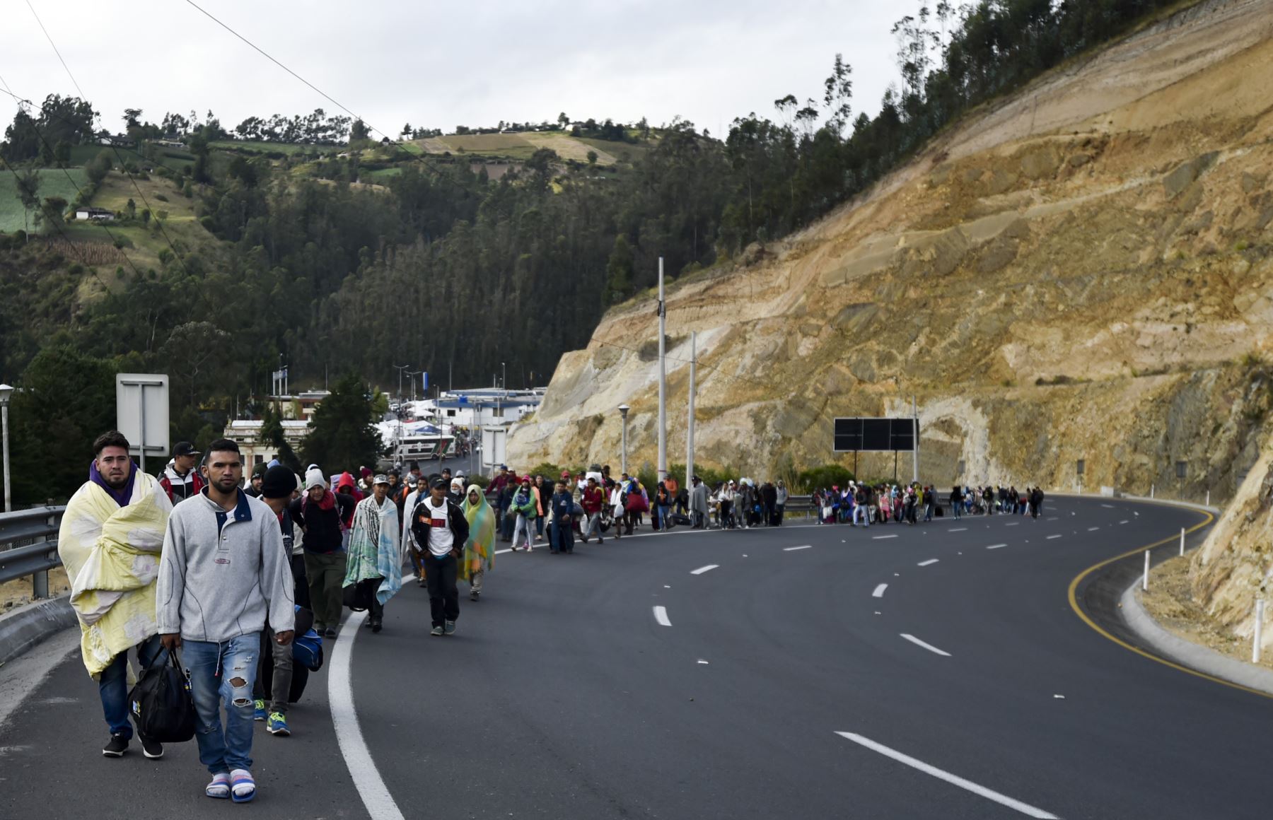 Los venezolanos que se dirigen a Perú caminan a lo largo de la carretera Panamericana en Tulcán, Ecuador, después de cruzar desde Colombia, el 21 de agosto de 2018. AFP