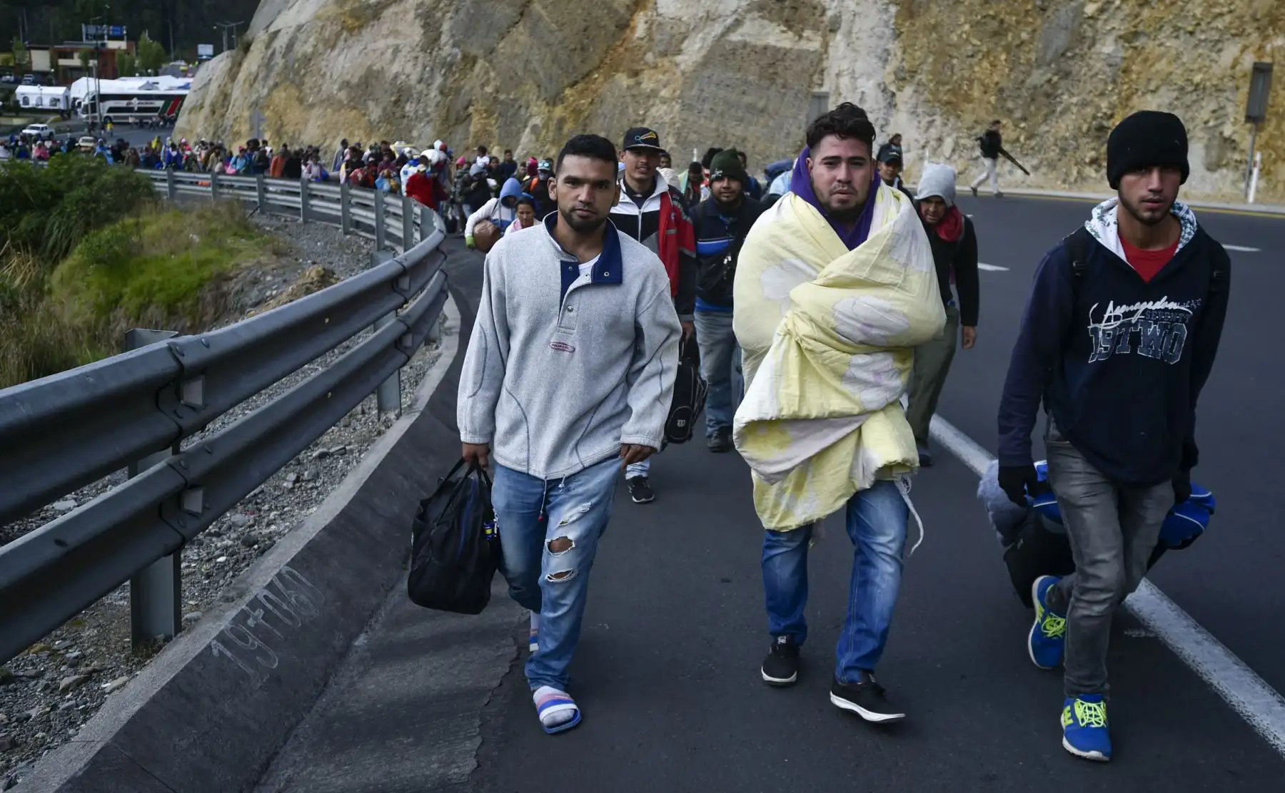 Los venezolanos que se dirigen a Perú caminan a lo largo de la carretera Panamericana en Tulcán, Ecuador, después de cruzar desde Colombia, el 21 de agosto de 2018.AFP