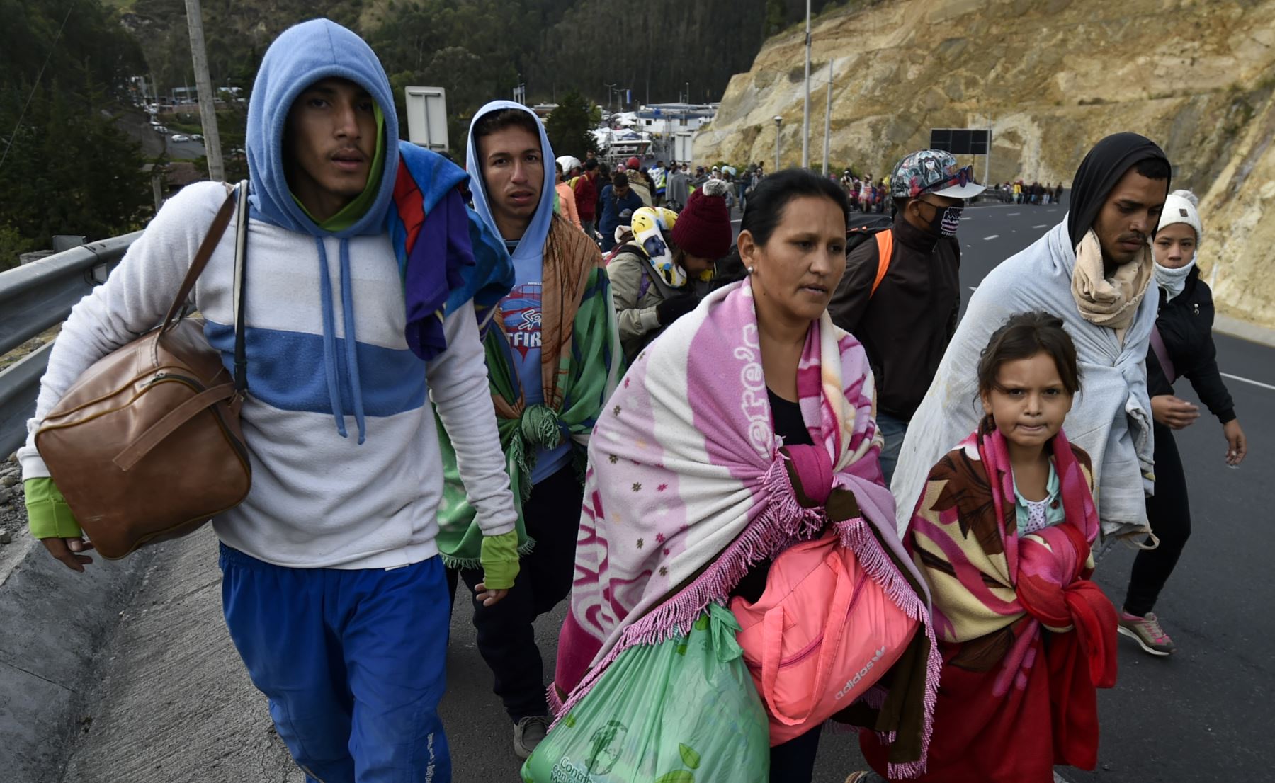 Los venezolanos que se dirigen a Perú caminan a lo largo de la carretera Panamericana en Tulcán, Ecuador, después de cruzar desde Colombia, el 21 de agosto de 2018.AFP