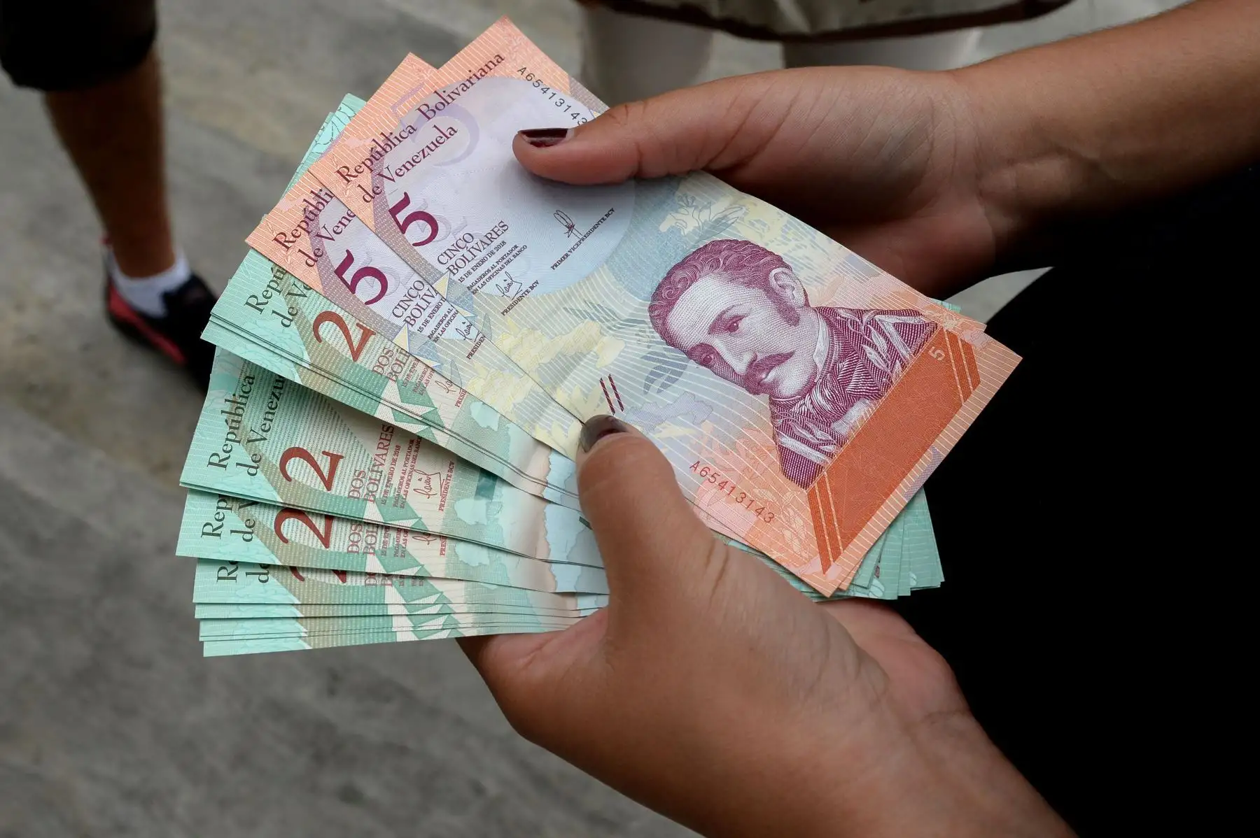 Una mujer muestra los nuevos bolívares en el centro de Caracas el 21 de agosto del 2018. Foto: AFP.