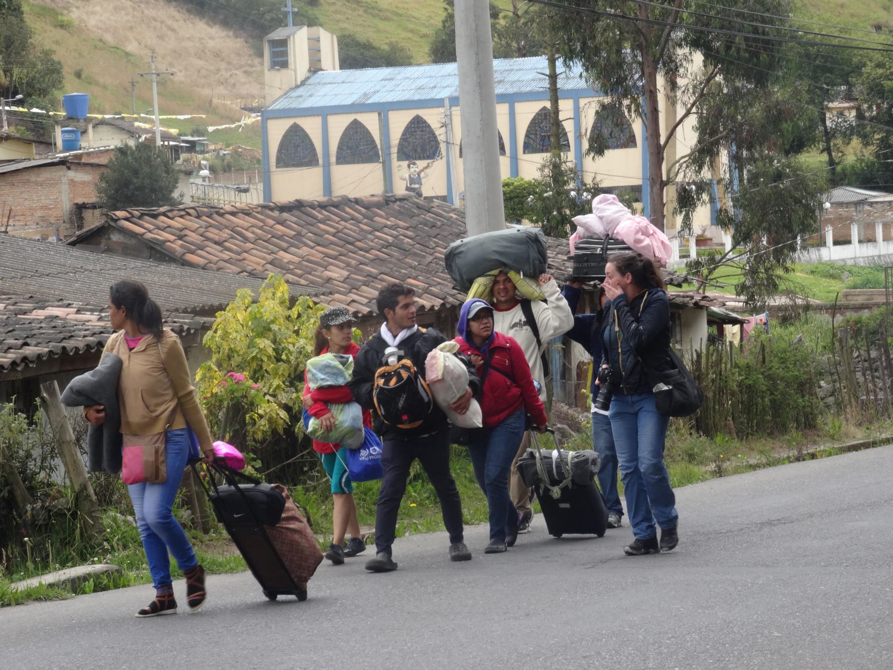 Inmigrantes venezolanos caminan con sus pertenencias por la Panamericana norte a 10 km de Tulcán (Ecuador). Foto: Efe.