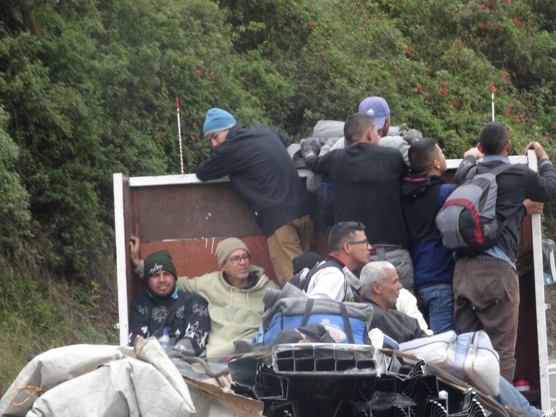 Inmigrantes venezolanos viajan en la parte trasera de un camión por la panamericana norte a 10 km de Tulcán. Foto: Efe.