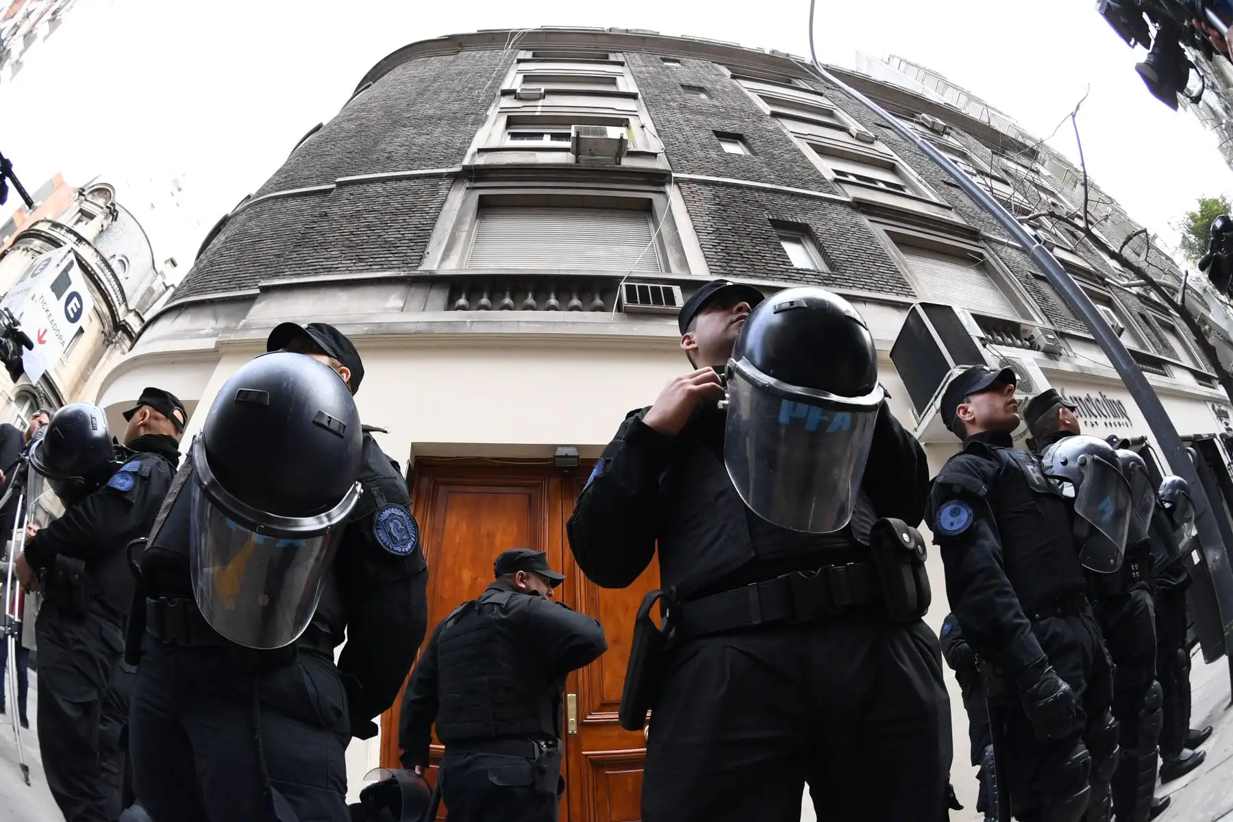 Agentes de la policía federal argentina custodian la entrada de un edificio donde la ex presidenta argentina y actual senadora Cristina Fernández de Kirchner es propietaria de un piso, durante una redada como parte del llamado caso de cuadernos de corrupción, en el barrio Recoleta, Buenos Aires, el 23 de agosto. 2018. Foto:AFP