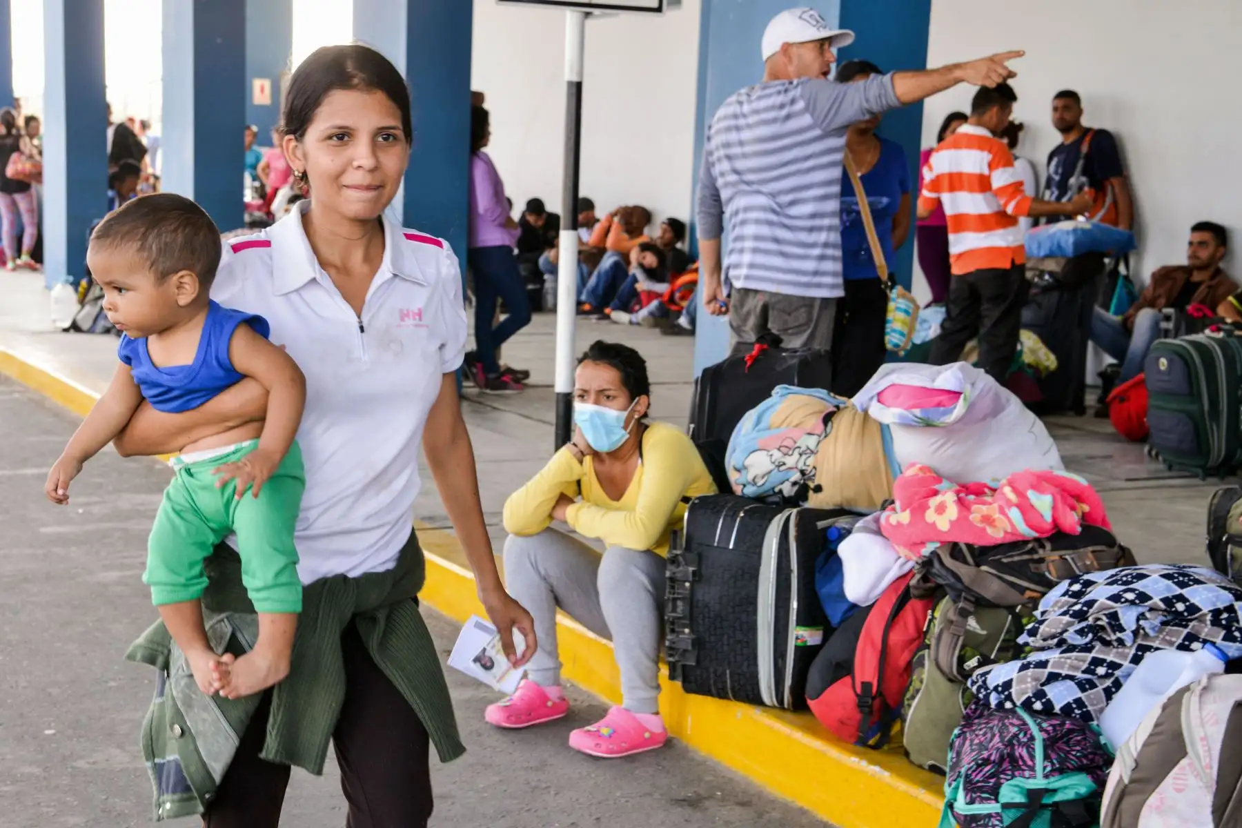 Una mujer venezolana camina con un bebé en brazos en el centro de atención de la frontera binacional (CEBAF) en Tumbes, al norte de Perú, en la frontera con Ecuador, el 23 de agosto de 2018. Foto: AFP