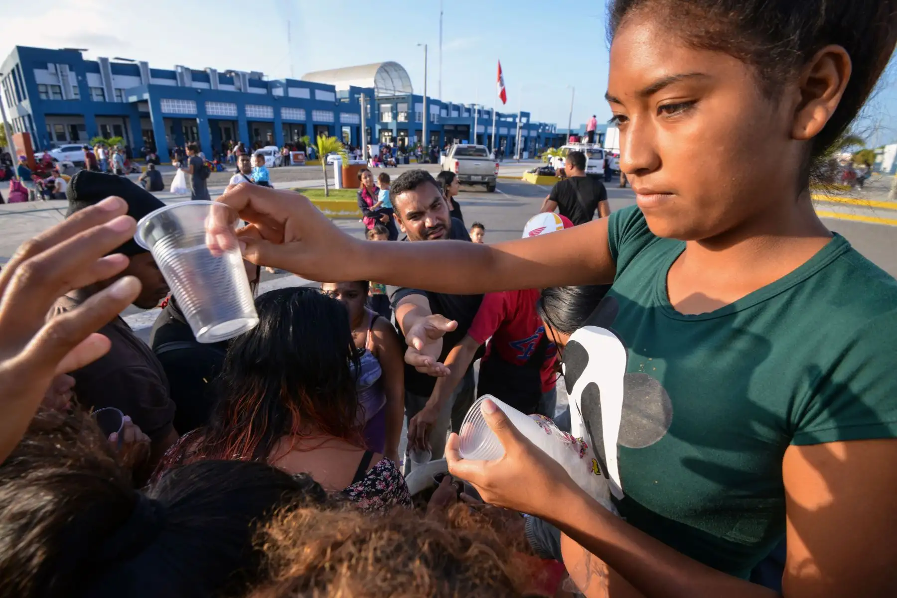 Los venezolanos reciben alimentos de voluntarios religiosos mientras esperan una autorización que les permita ingresar al Perú, en el centro de atención de la frontera binacional (CEBAF) en Tumbes, al norte de Perú, en la frontera con Ecuador, el 23 de agosto de 2018.AFP
