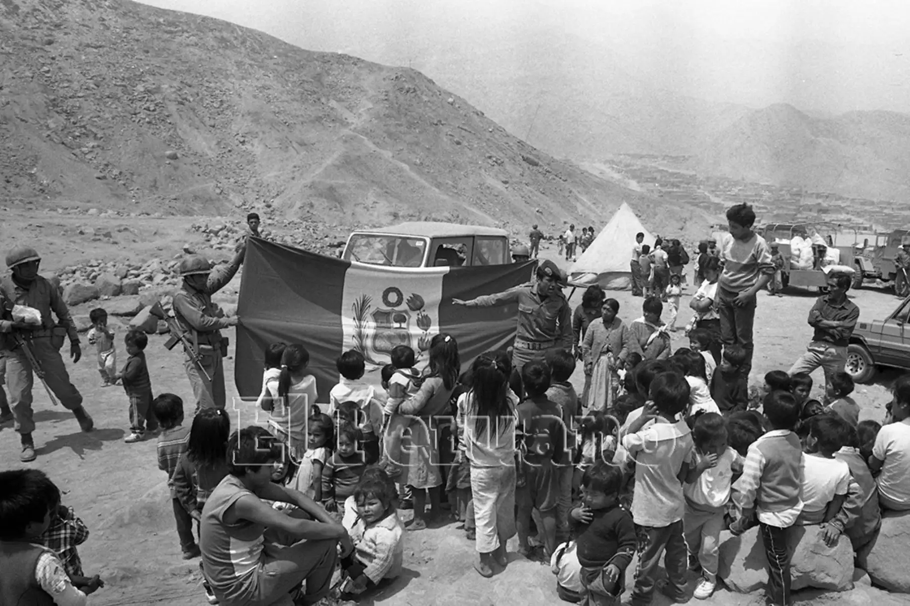 Miembros del Ejército Peruano enseñan los símbolos patrios a niños de la Comunidad de Huaycán durante una campaña de acción cívica (Lima, 1991). Foto: Archivo Histórico de EL PERUANO / Onésimo Bottoni
