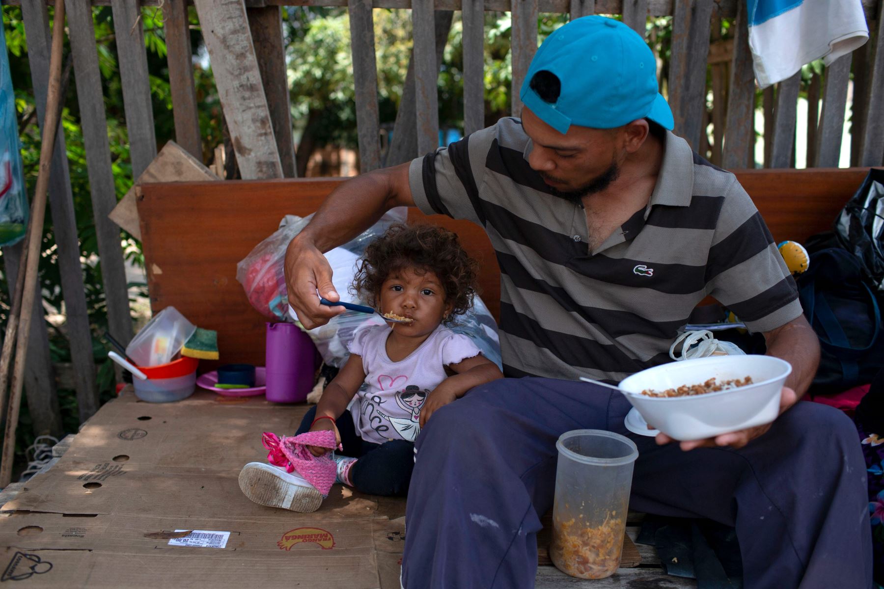 Un venezolano y su hija comen en el lado de una carretera en Boa Vista Foto: AFP