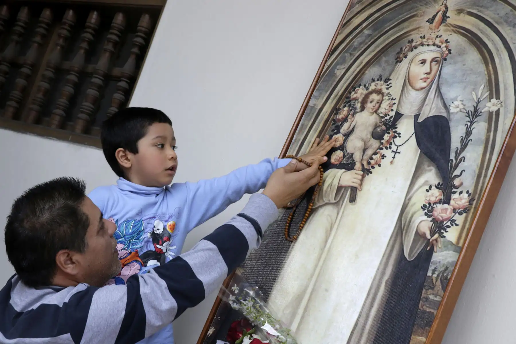 Padre con su hijo saludan una imagen  de Santa Rosa. Foto: ANDINA/Melina Mejía