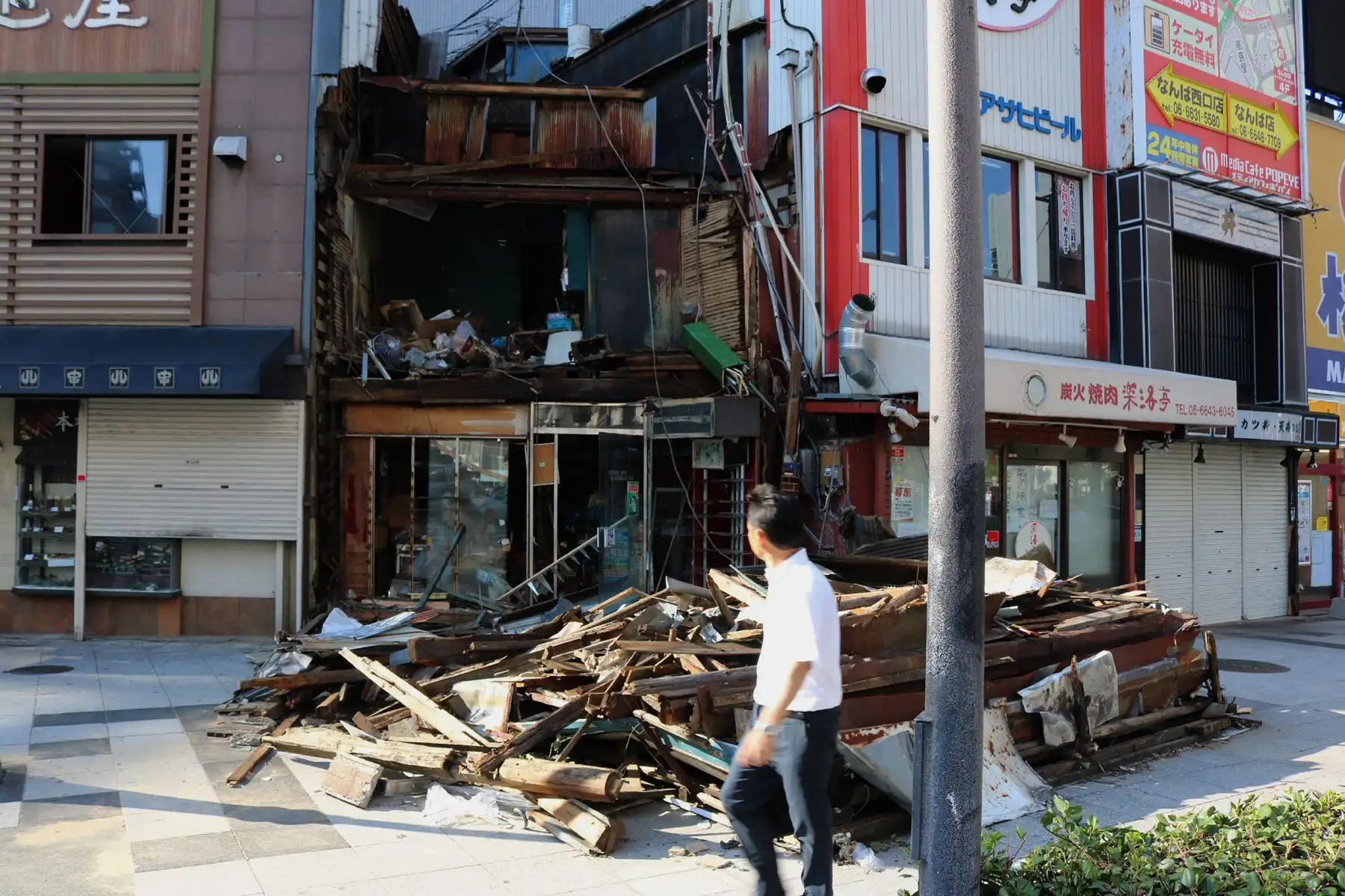 Un hombre pasa frente a una casa de madera destruida por los fuertes vientos del tifón Jebi en Osaka el 5 de septiembre de 2018.
El tifón Jebi dejó un rastro de destrucción en todo el país, matando a 11 personas e hiriendo a cientos más mientras golpeaba el oeste de Japón con vientos feroces y lluvias torrenciales. / AFP